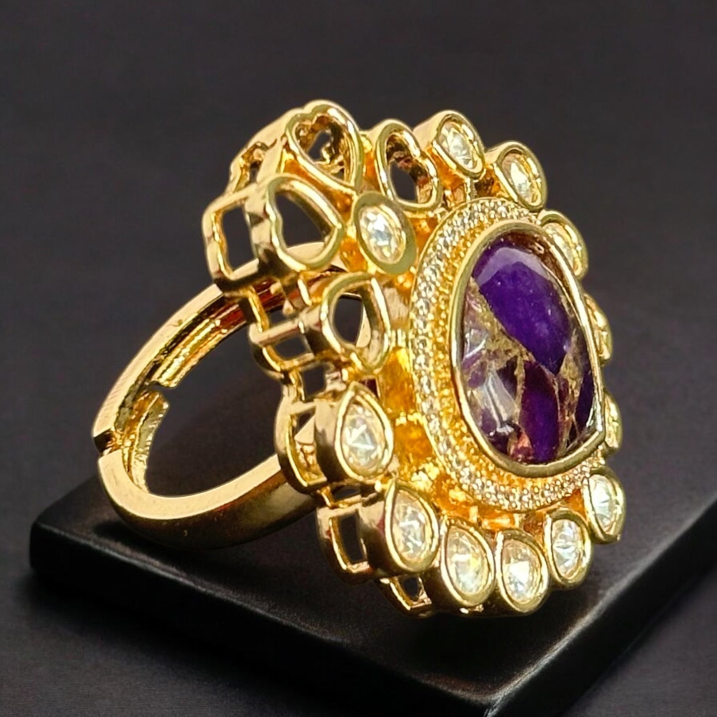 Elegant adjustable Polki Kundan finger ring with a bold purple center stone surrounded by intricate gold and diamond accents.