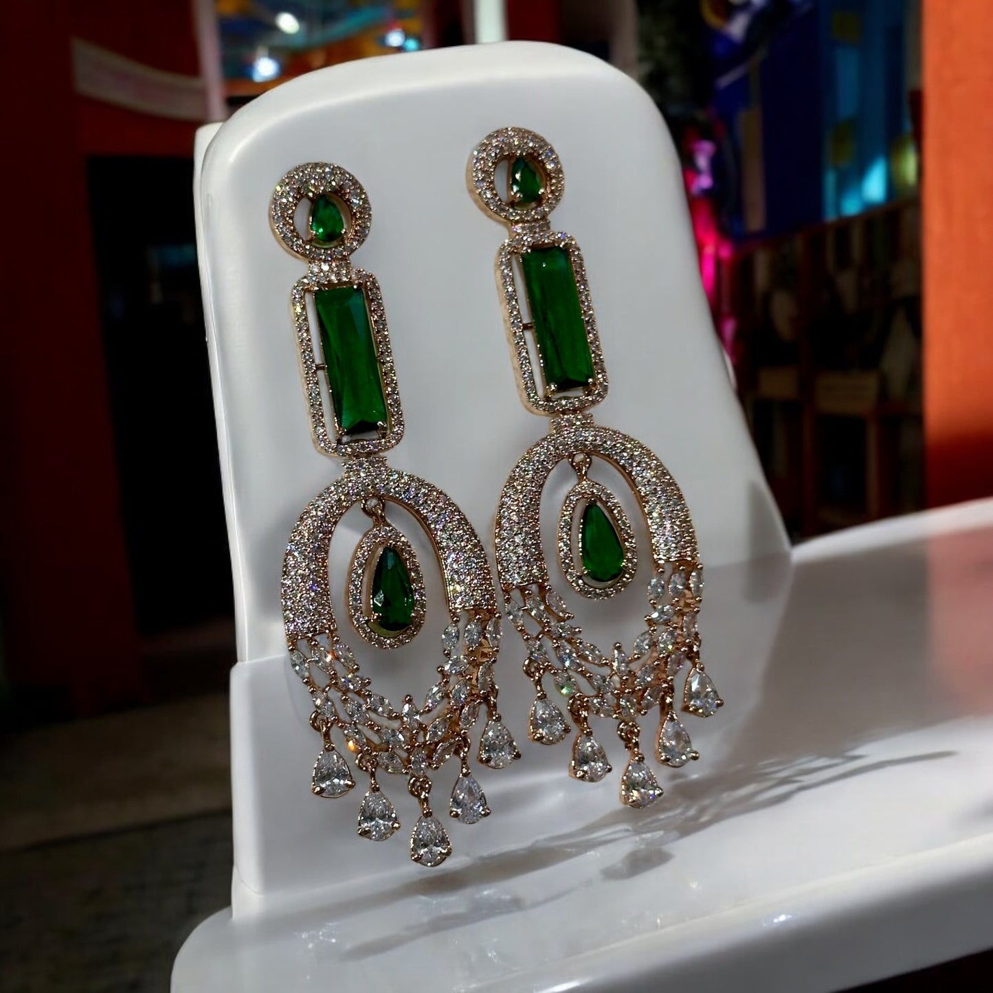 Green American Diamond Statement Earring on a white jewelry display stand