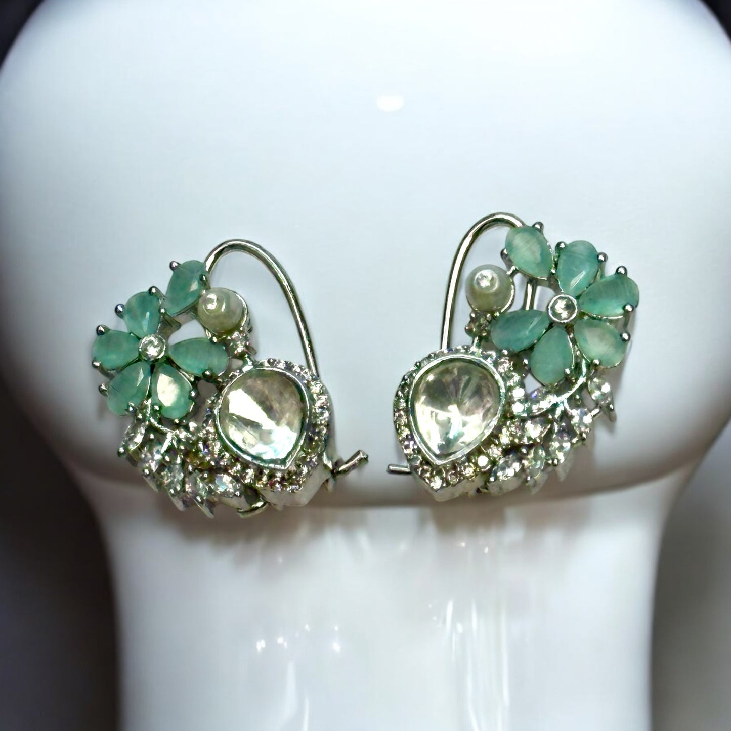 Exquisite American diamond partywear earrings with green floral detailing and pearl accents.