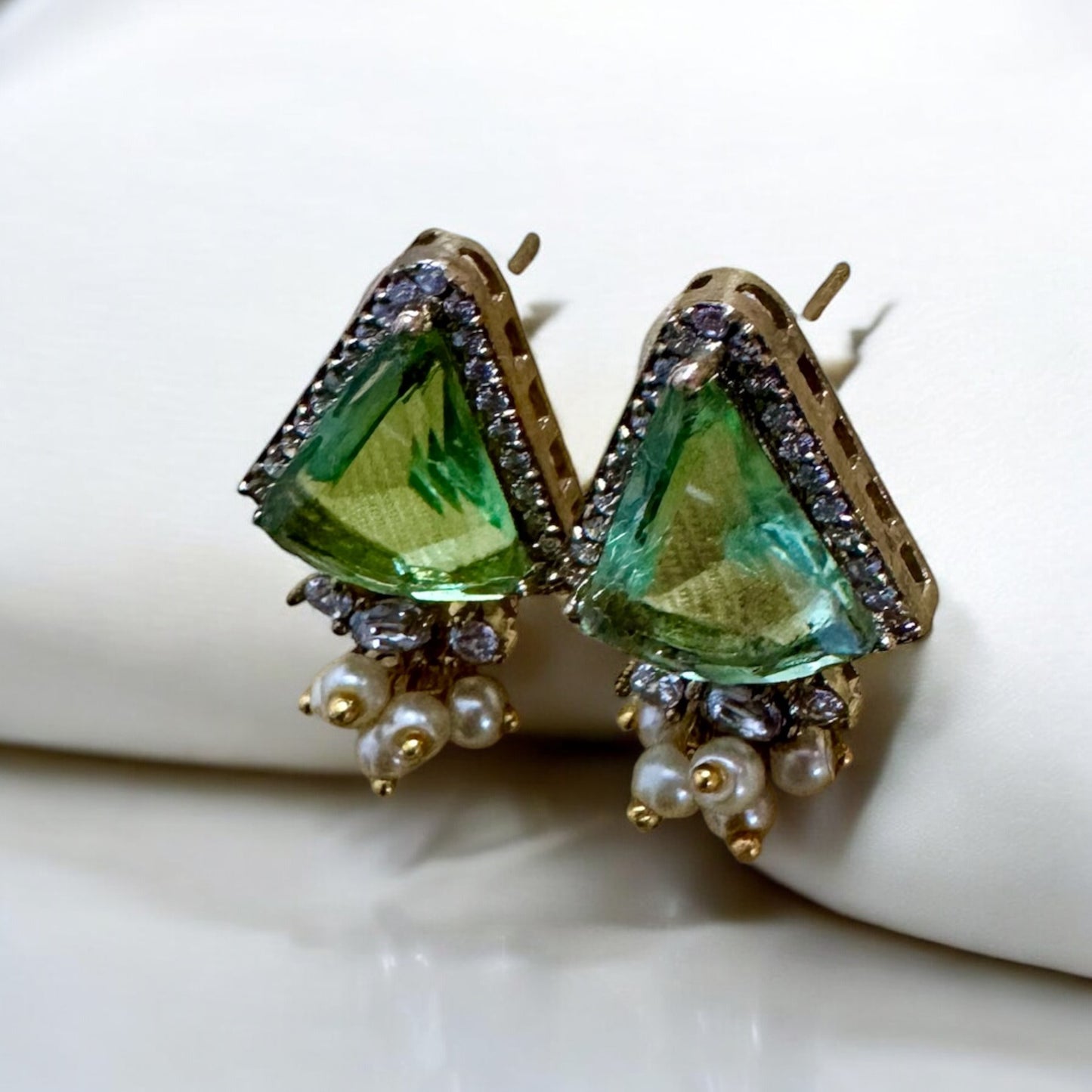 Green stoned Doublet American Diamond In Apala Polish Earrings on a white coloured fabric background.