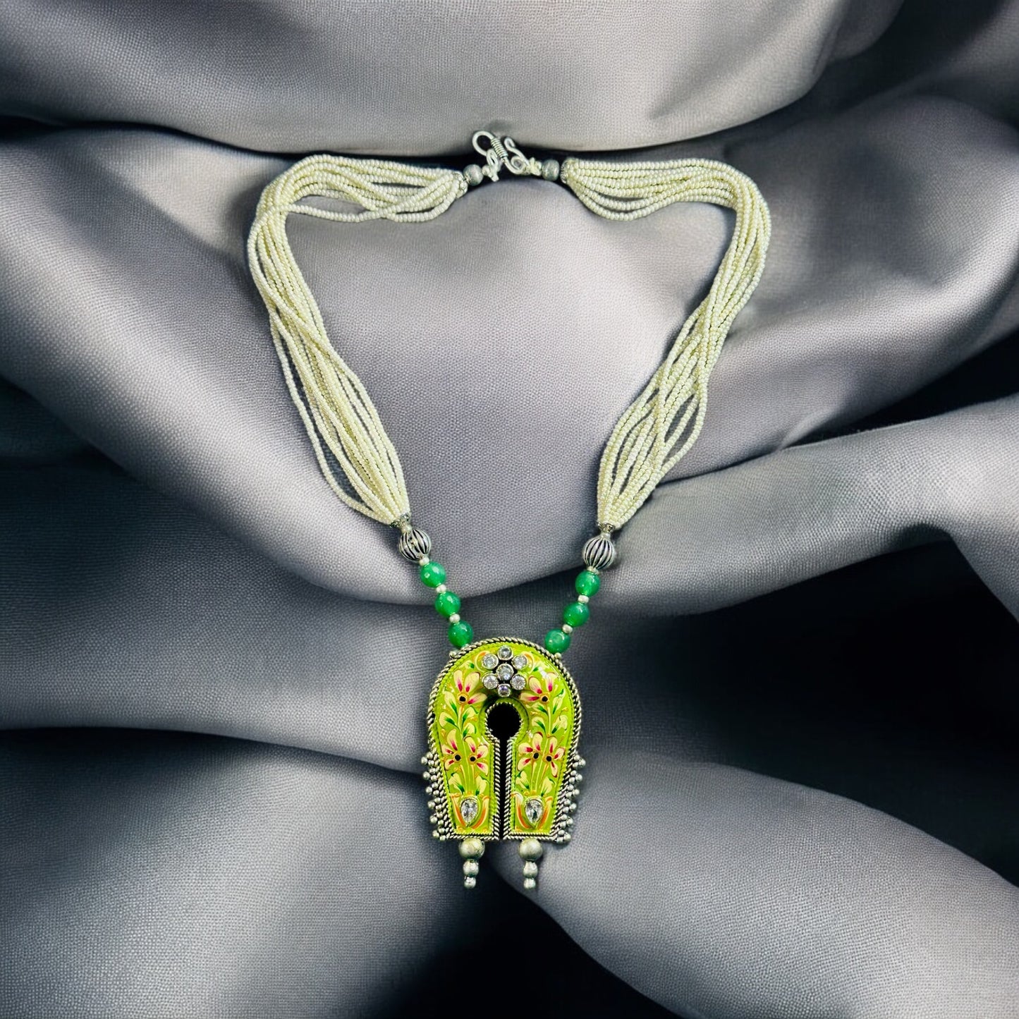 Statement Piece Hand Painted Pendant Silver Look Alike Necklace placed on a grey fabric background.