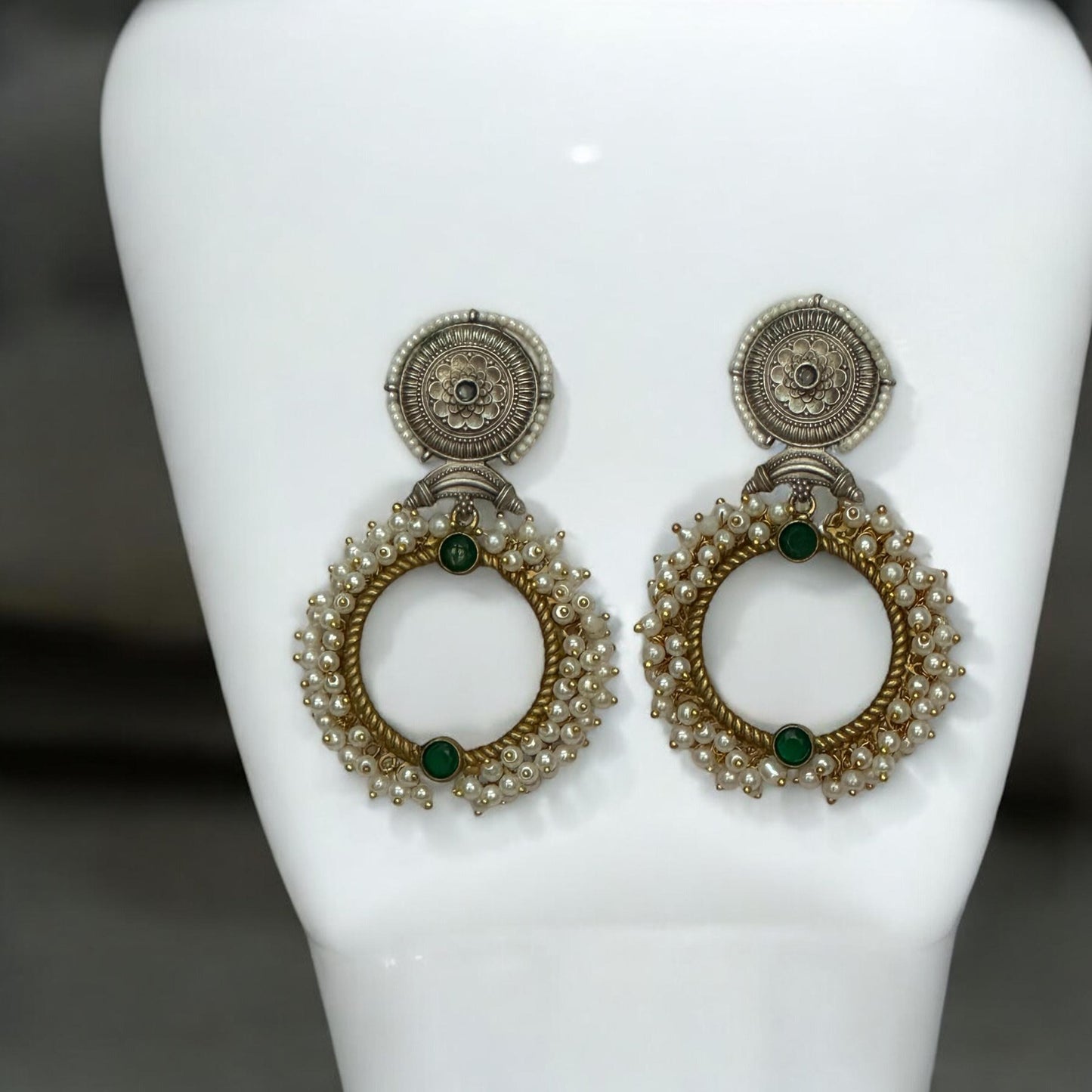 Handmade dual-tone Pachi Kundan earrings with pearl detailing and green stones placed on a white jewellery display stand β Bella & Diva