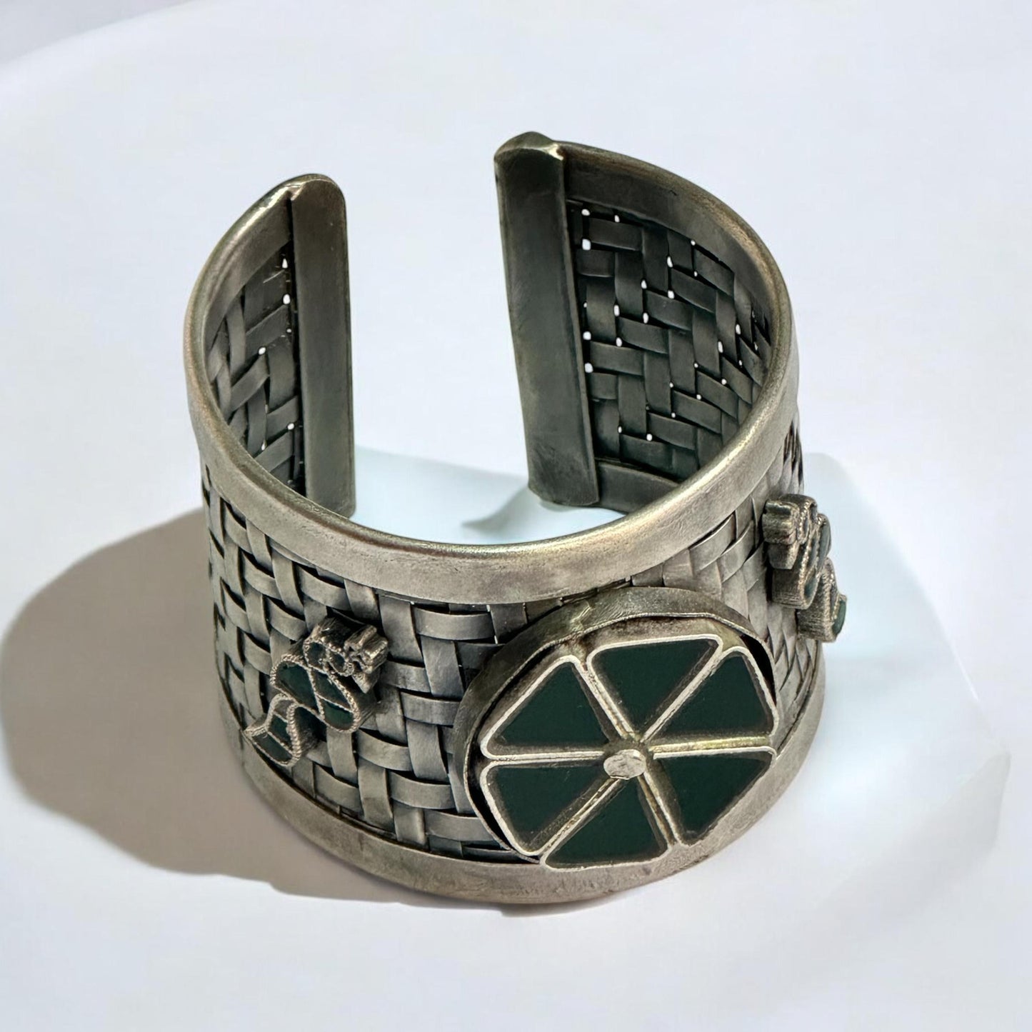 Handmade silver adjustable broad kada featuring a woven texture and green Pachi Kundan floral design, displayed on a white background with intricate detailing.