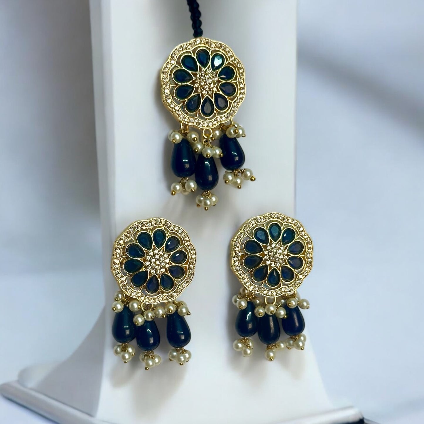 Kundan Pearl Navy Blue Necklace Set's Earrings and Tikka - Traditional Indian Gold Plated Jewelry, Featuring Navy Blue Beads and Pearl Drops - Displayed on White Jewelry Stand for Elegant Presentation