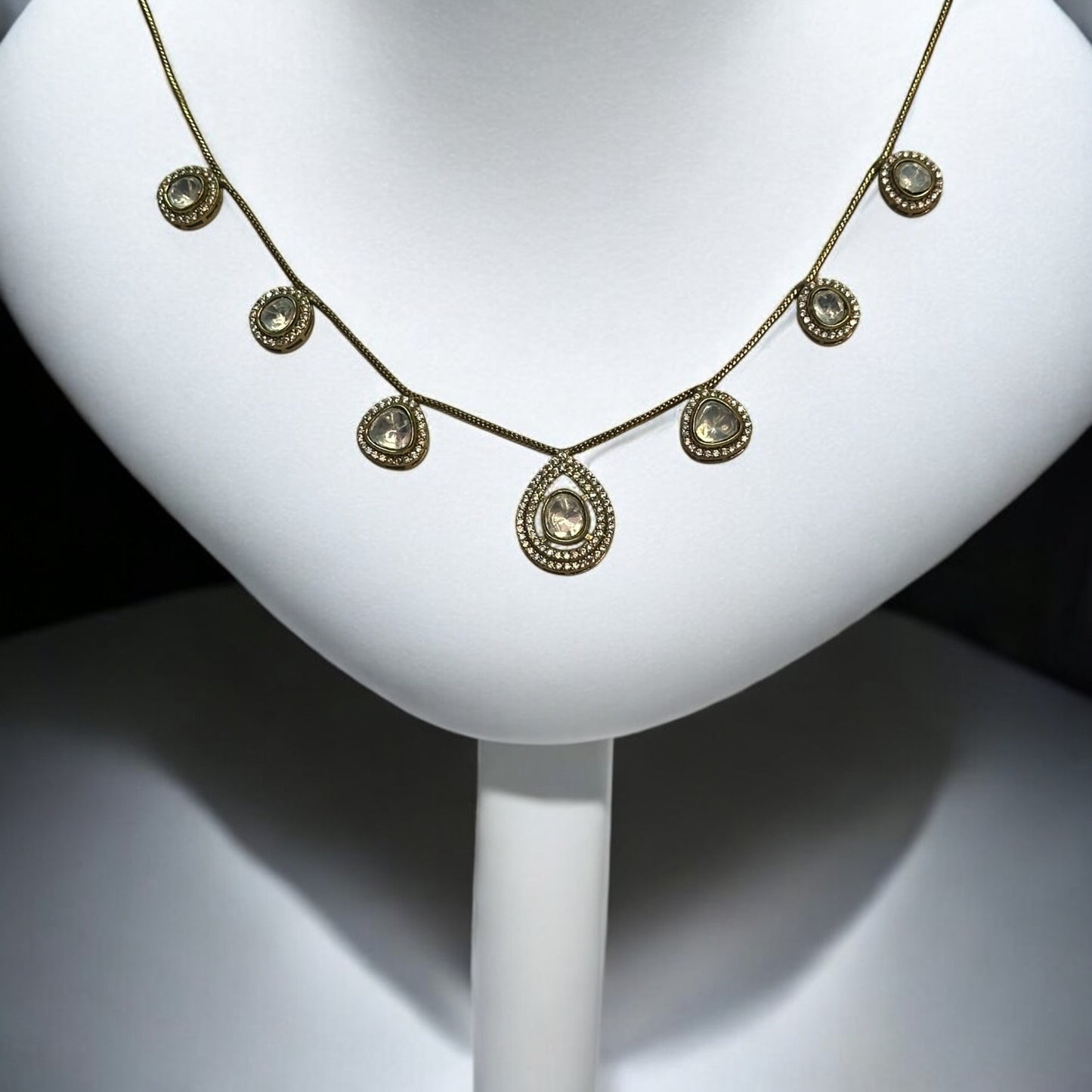 Moissanite chain design necklace in golden colour places on a white colored jewellery display stand.