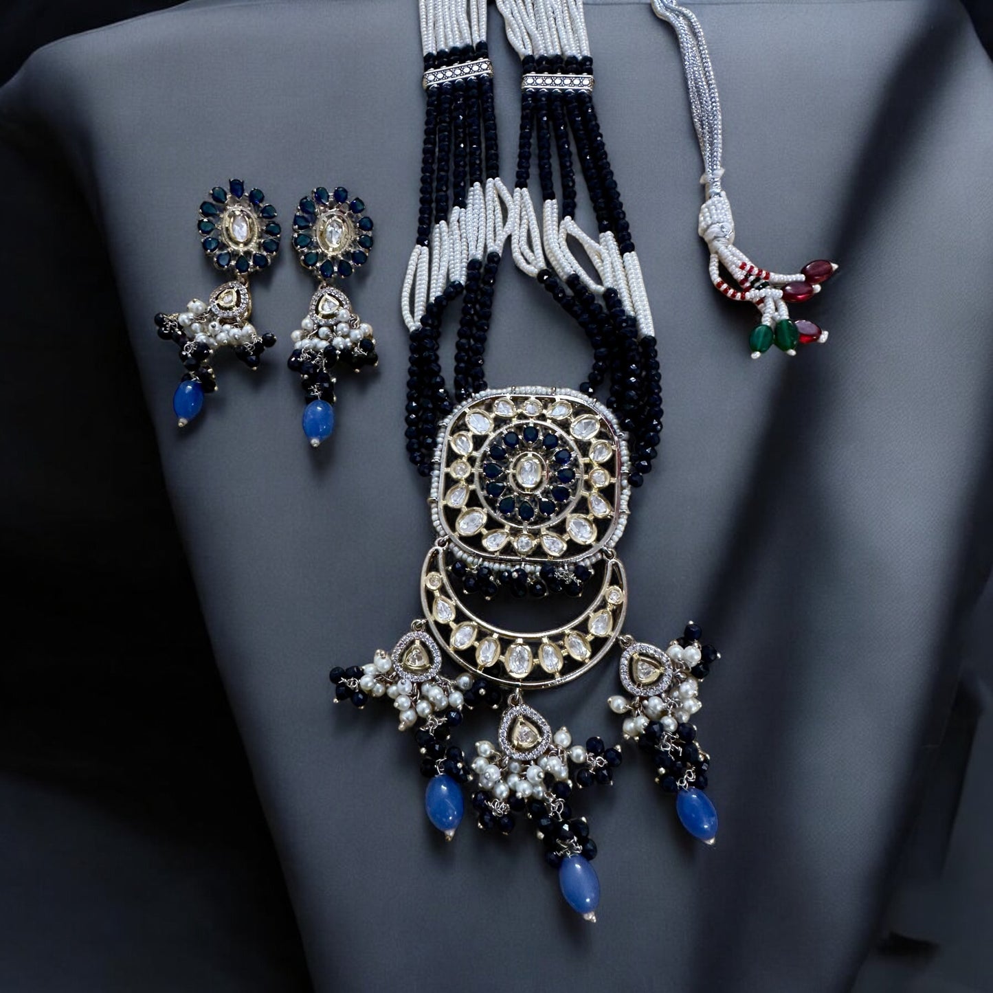Polki Kundan with American Diamond Rani Har Necklace Set with earrings lying on a shiny black fabric background