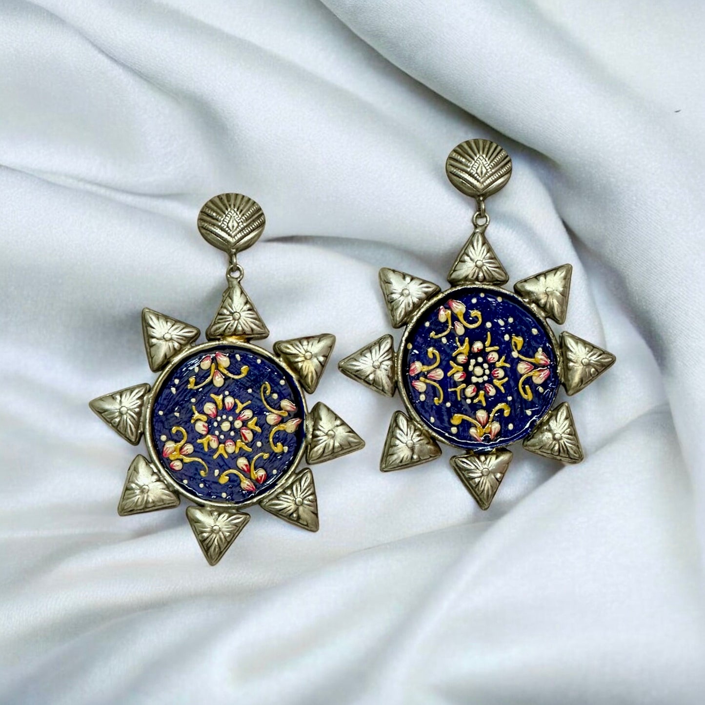 Oxidized silver replica necklace set's large blue floral earrings on a white fabric β Bella & Diva