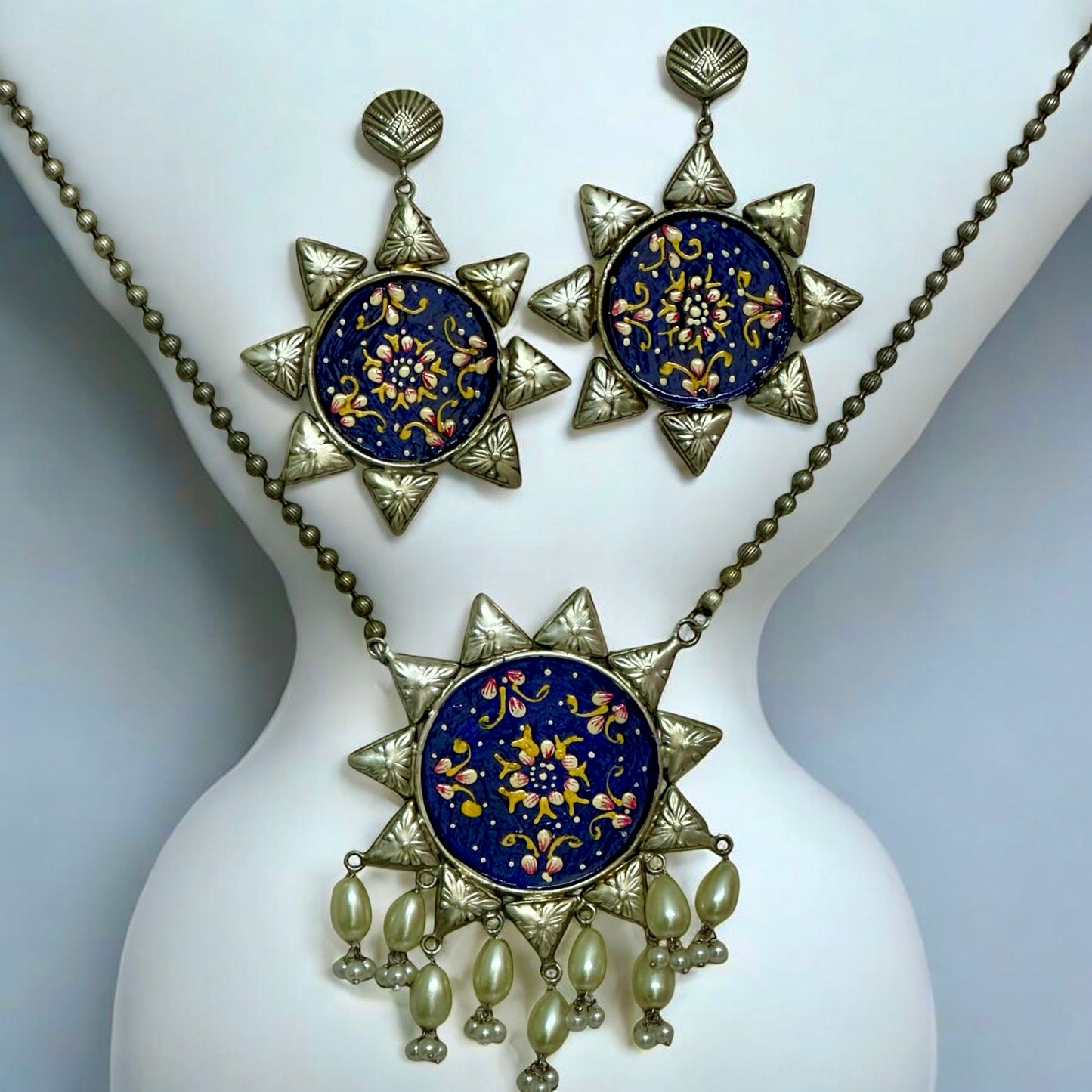 Oxidized silver replica necklace with large blue floral pendant and matching earrings on mannequin β Bella & Diva