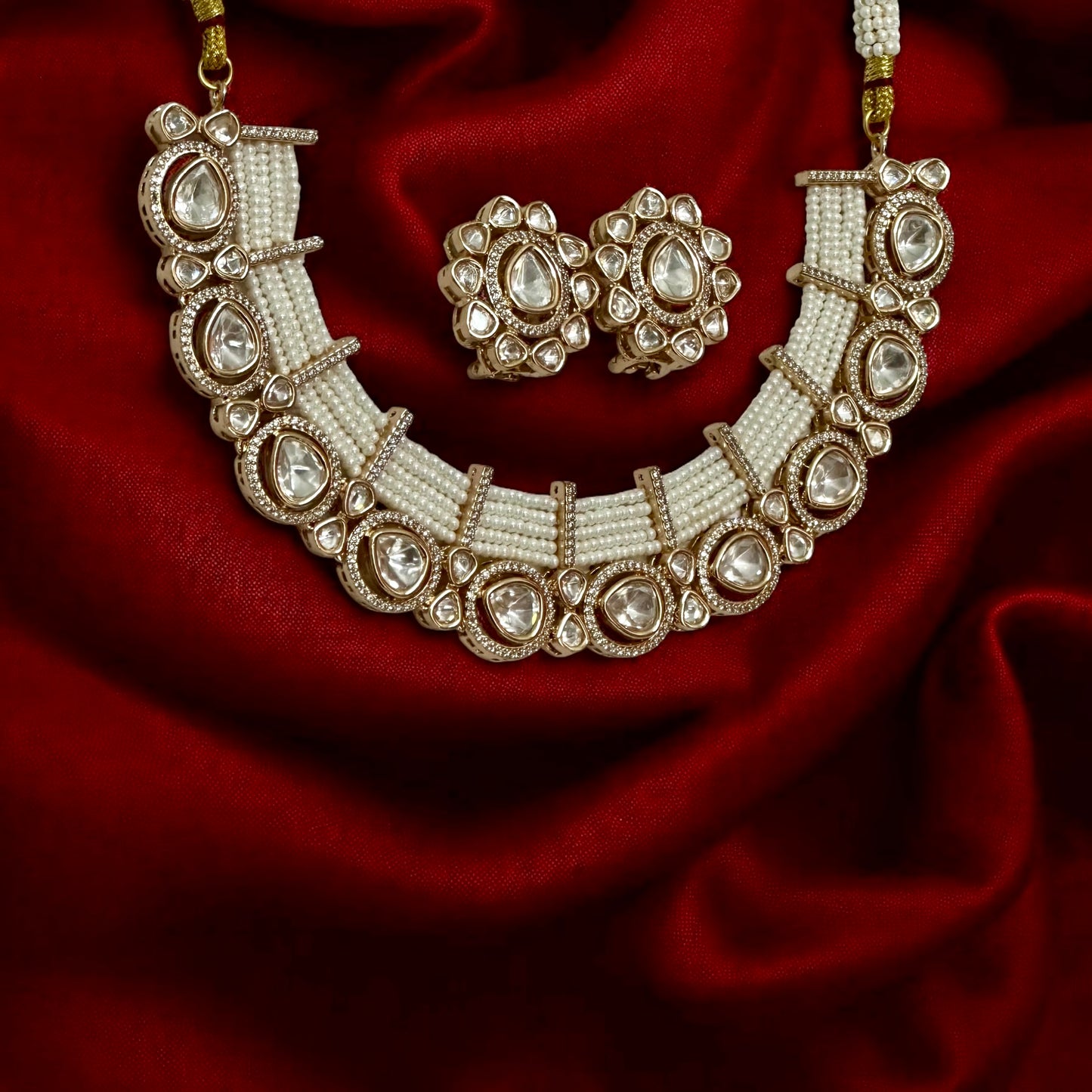 Tyani Kundan pearl necklace set with large matching studs displayed on red silk fabric β Bella & Diva