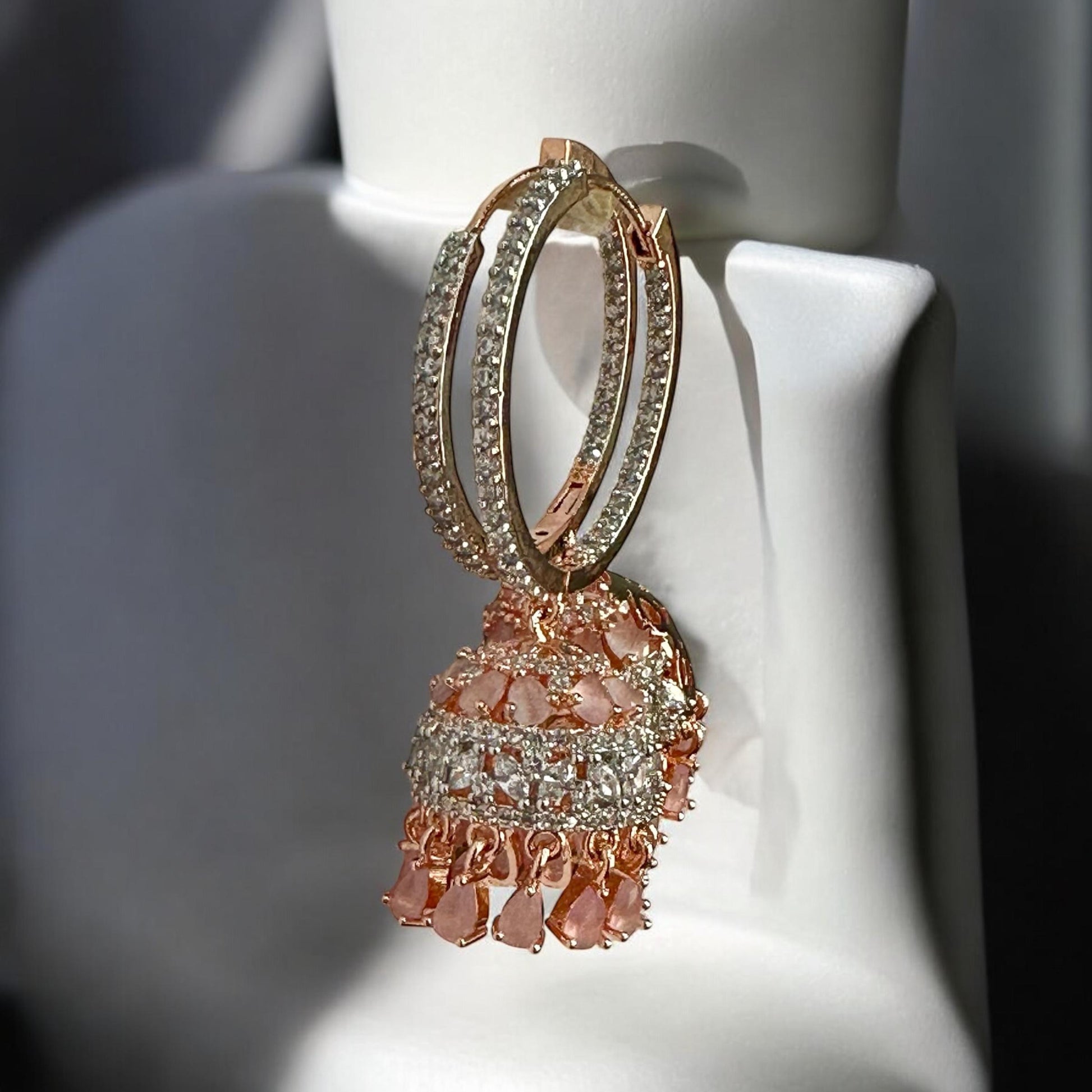 American Diamond peach colour big jhumka earrings with crystal detailing and rose gold finish – designer Indian jewellery for weddings and parties.
