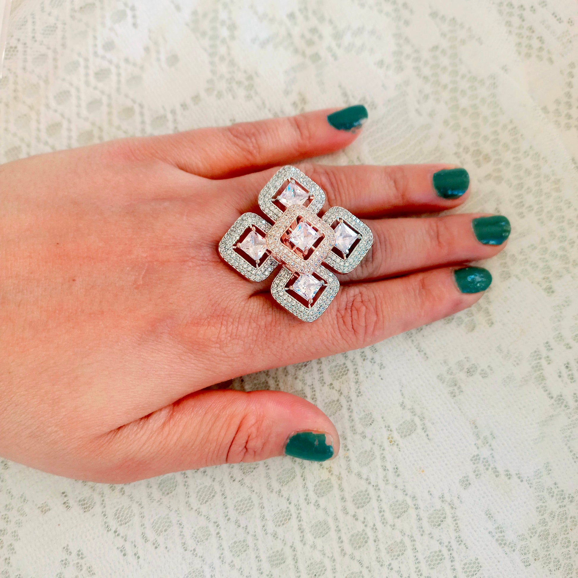American Diamond Finger Ring in 5 squares design with a diamond in each square, worn on a hand with green fingel nails and white background 