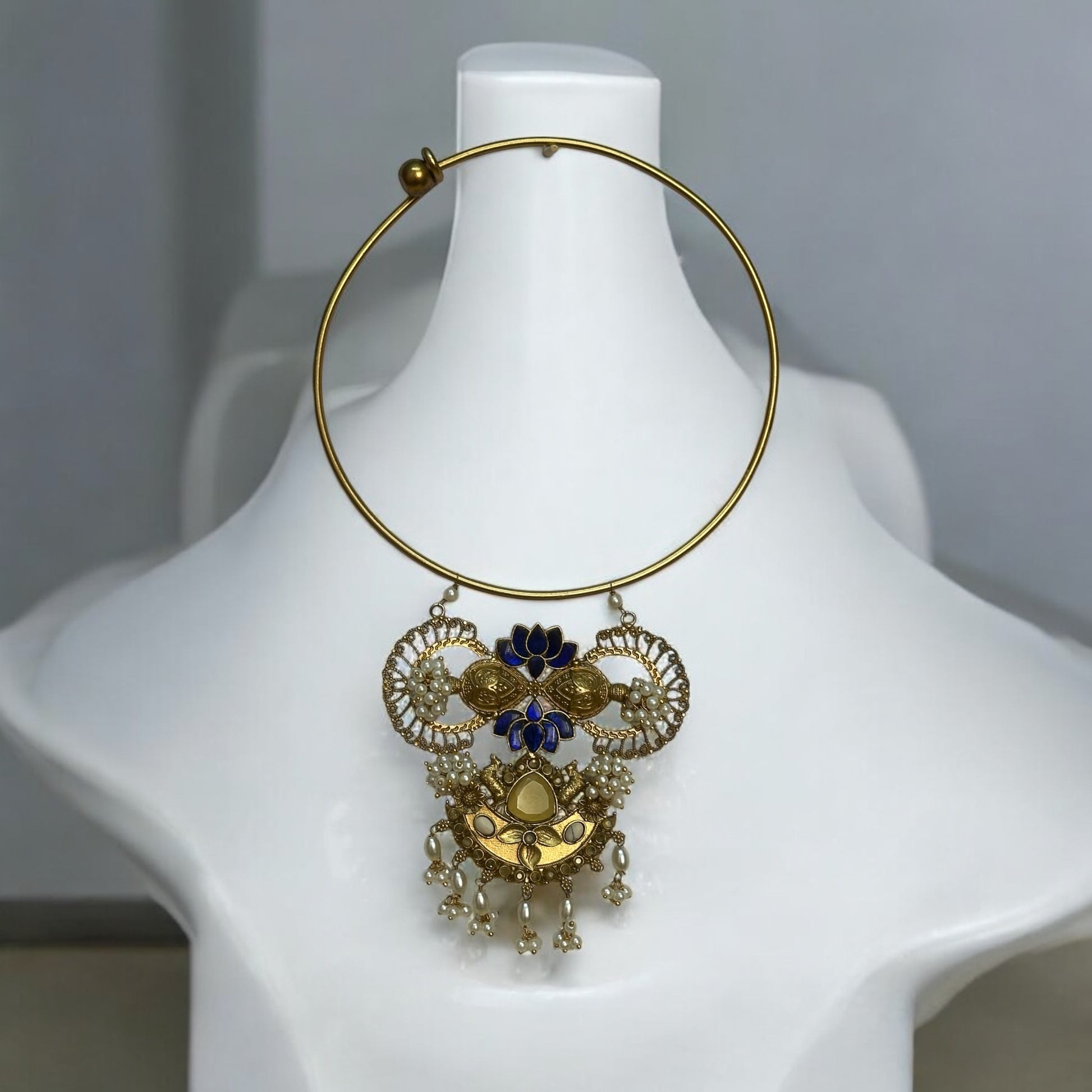 Amrapali Fusion Hasli Necklace – gold-tone necklace with intricate detailing, pearl accents, and vibrant blue enamel work. A statement fusion piece ideal for festive and contemporary outfits.