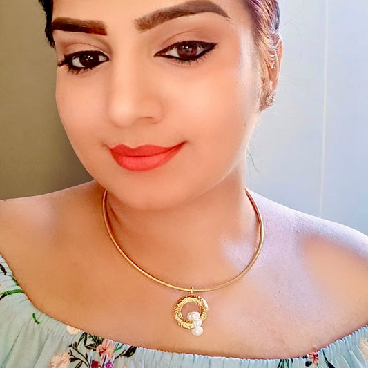 A model displaying Anti-tarnish gold chain with a circular pendant featuring intricate detailing and three small pearls.