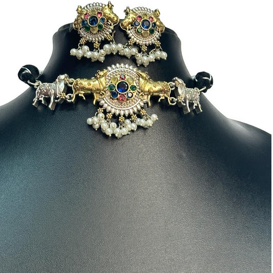 Dual Tone Silver Look-Alike Choker Set in Multi-Color with Intricate Nandi Design and Matching Earrings placed on a black coloured jewellery display stand. 