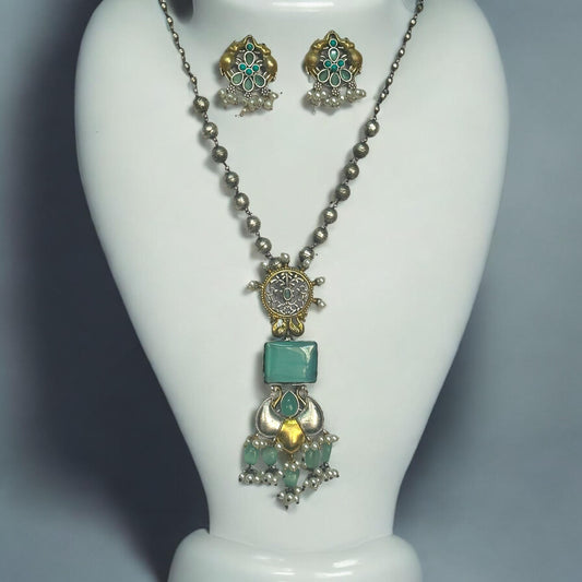 Dual Tone Silver Replica Long Matar Mala Design Necklace Set featuring sky-colored stones and intricate dual-tone silver-gold craftsmanship, displayed on a white mannequin bust against a soft gradient background.