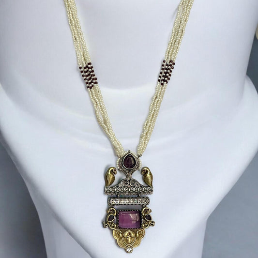  Dual Tone Silver Replica Purple Necklace Set with a multi-strand white pearl mala, featuring a bird motif pendant with purple stones, displayed on a white mannequin.