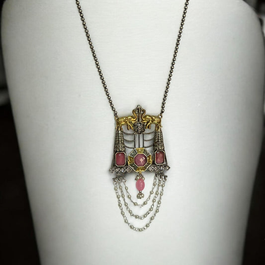 Dual-tone Silver Replica Long Pendant Necklace with Pink Monalisa Stone Accents and Intricate Chain Detailing PLACED ON A WHITE COLOURED JEWELLERY DISPLAY STAND. 