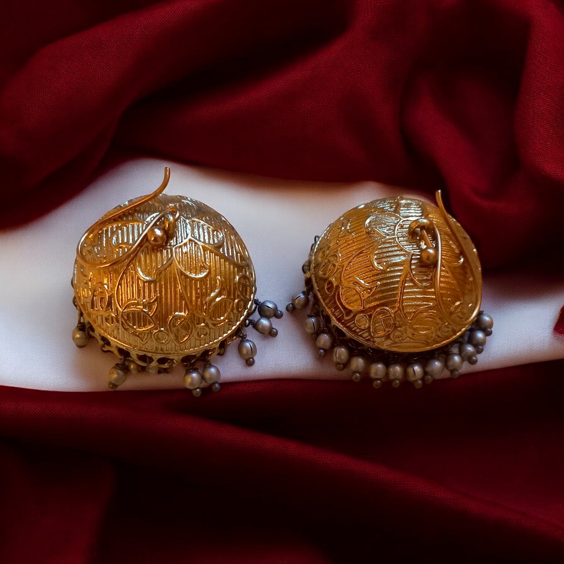Fusion Pachi Kundan choker's antique golden dome jhumkas on a red velvet background