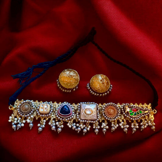 Fusion Pachi Kundan choker with pearls and colourful motifs paired with antique gold dome jhumkas on a red velvet background