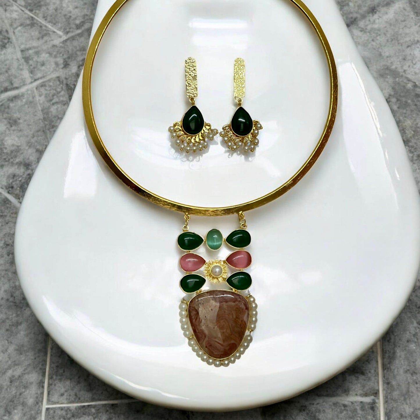 Golden fusion hasli necklace with multicolour Monalisa stone pendant and matching earrings on white jewellery display stand – Bella & Diva