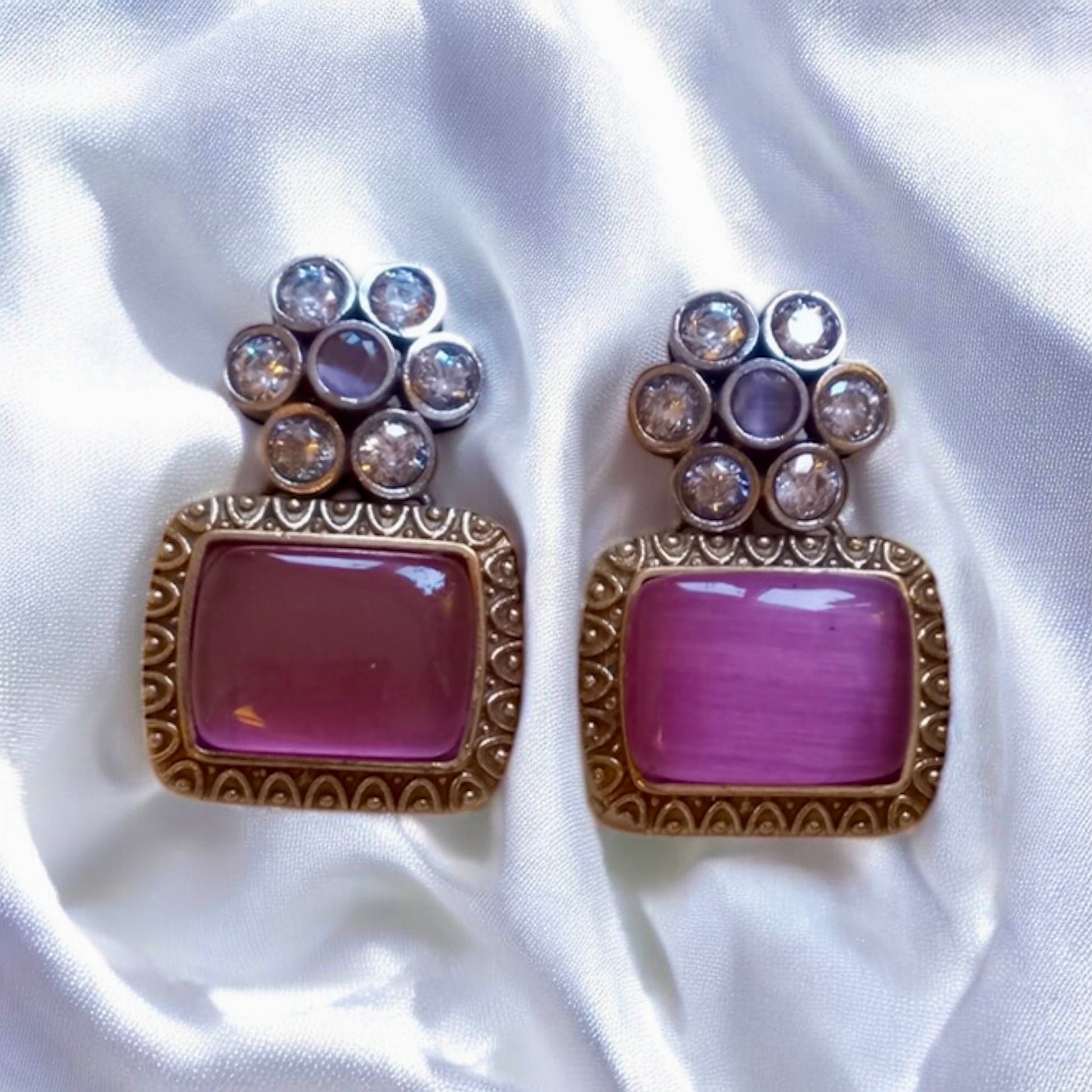 German silver pink Monalisa stones and antique detailingon  square stud earrings on satin background