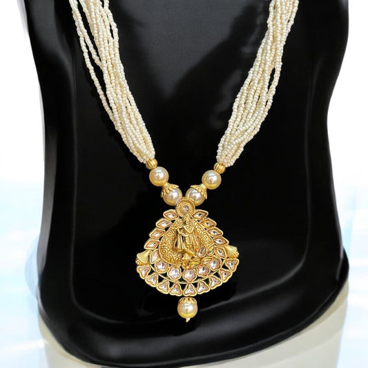 Pearl Mala with Krishna Design featuring multi-layered pearl strands and a gold-toned pendant intricately depicting Lord Krishna. Displayed on a black stand, showcasing the elegant craftsmanship and divine design.