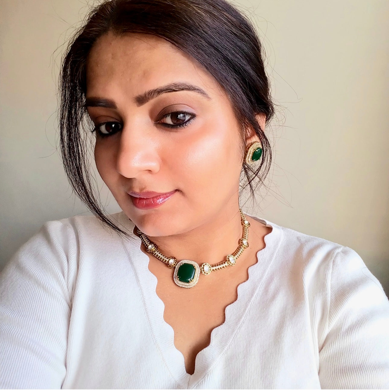 A model displaying a green coloured Premium Polki Kundan Necklace Set with Earrings  – elegant gold-tone necklace with vibrant green stones, polki kundan work, and matching stud earrings. Perfect for weddings and festive occasions.