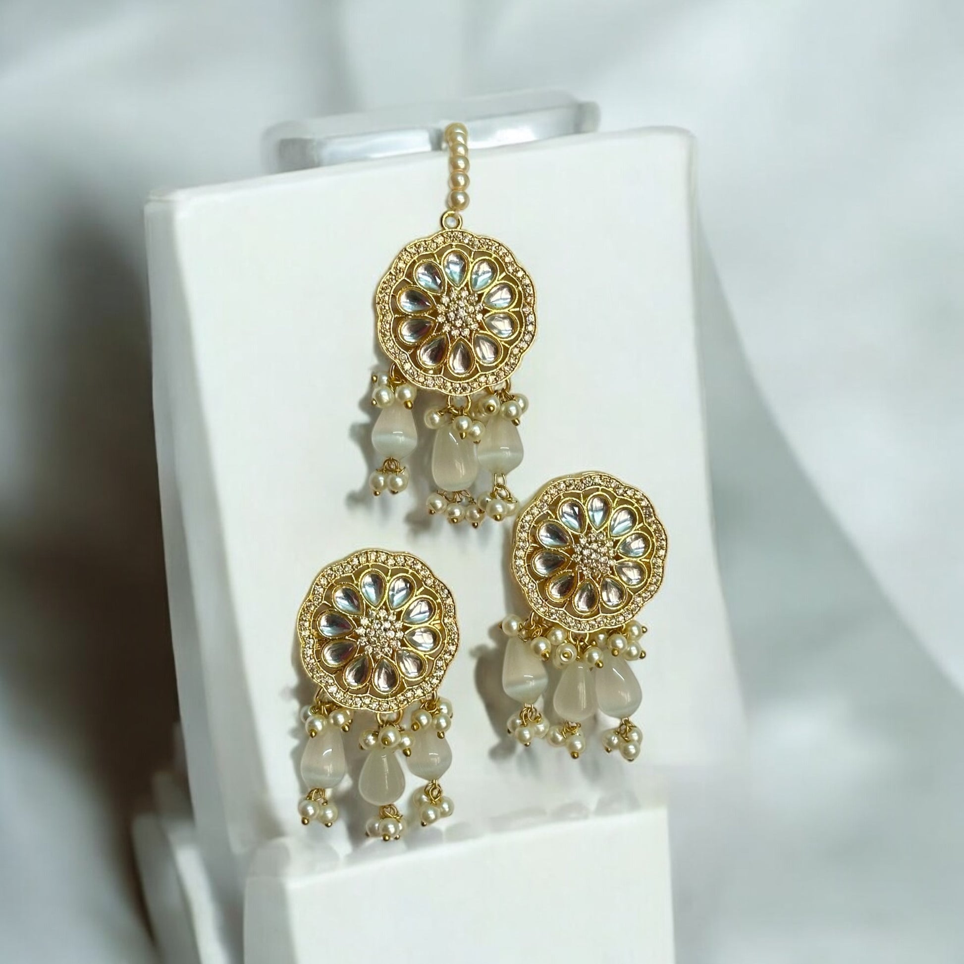 Kundan Pearl Golden Earrings and Tikka - Traditional Indian Gold Plated Jewelry, Featuring Golden Beads and Pearl Drops - Displayed on White Jewelry Stand for Elegant Presentation
