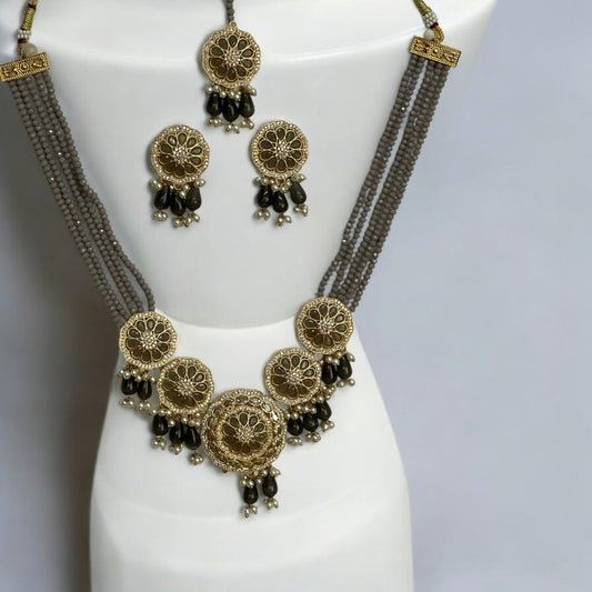 Kundan Pearl Grey Necklace Set with Earrings and Tikka – multi-layered grey beaded necklace featuring gold-toned kundan work, pearl accents, and matching earrings with tikka. Perfect for festive and wedding occasions.