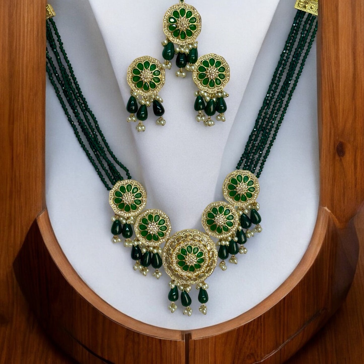 Kundan Pearl Green Necklace Set with Earrings and Tikka – multi-layered green beaded necklace with gold-tone kundan work, pearl accents, matching earrings, and a tikka. Perfect for weddings and festive occasions.