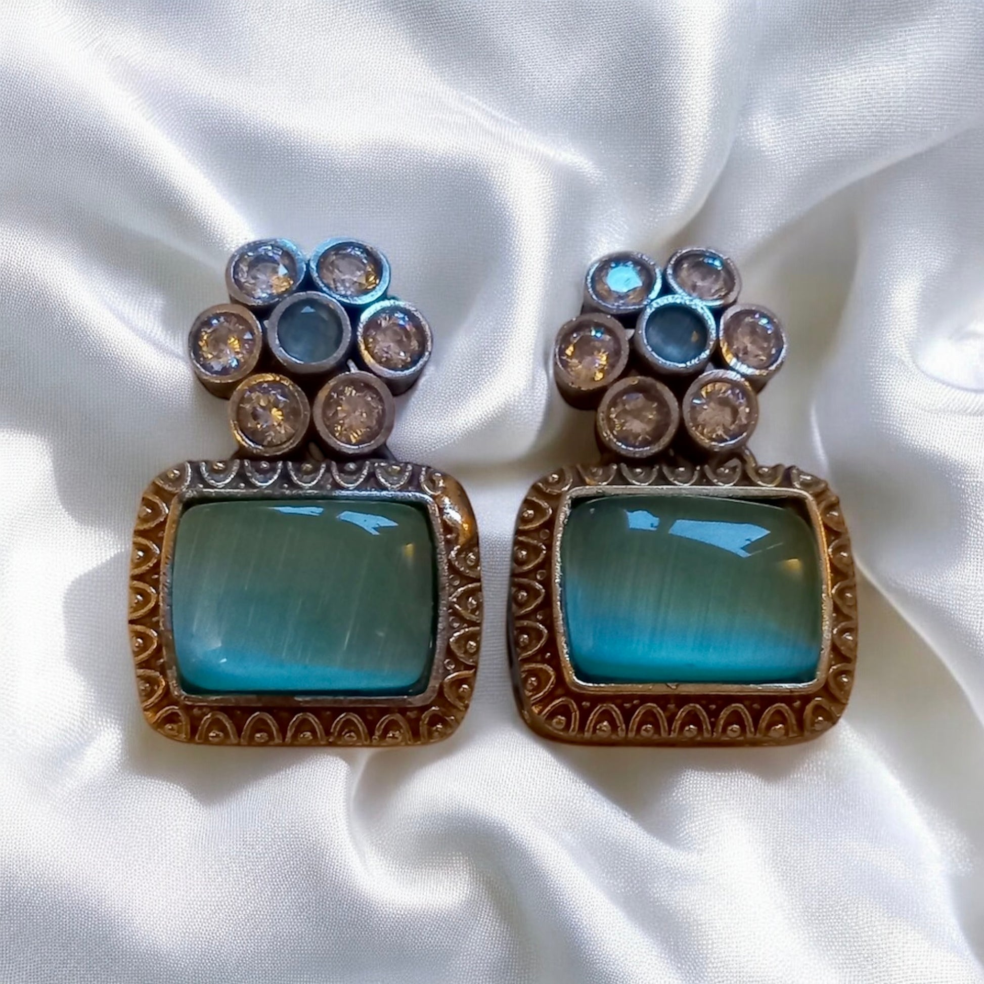 Mint green Monalisa stone Hasli-style German silver matching earrings on white fabric  background