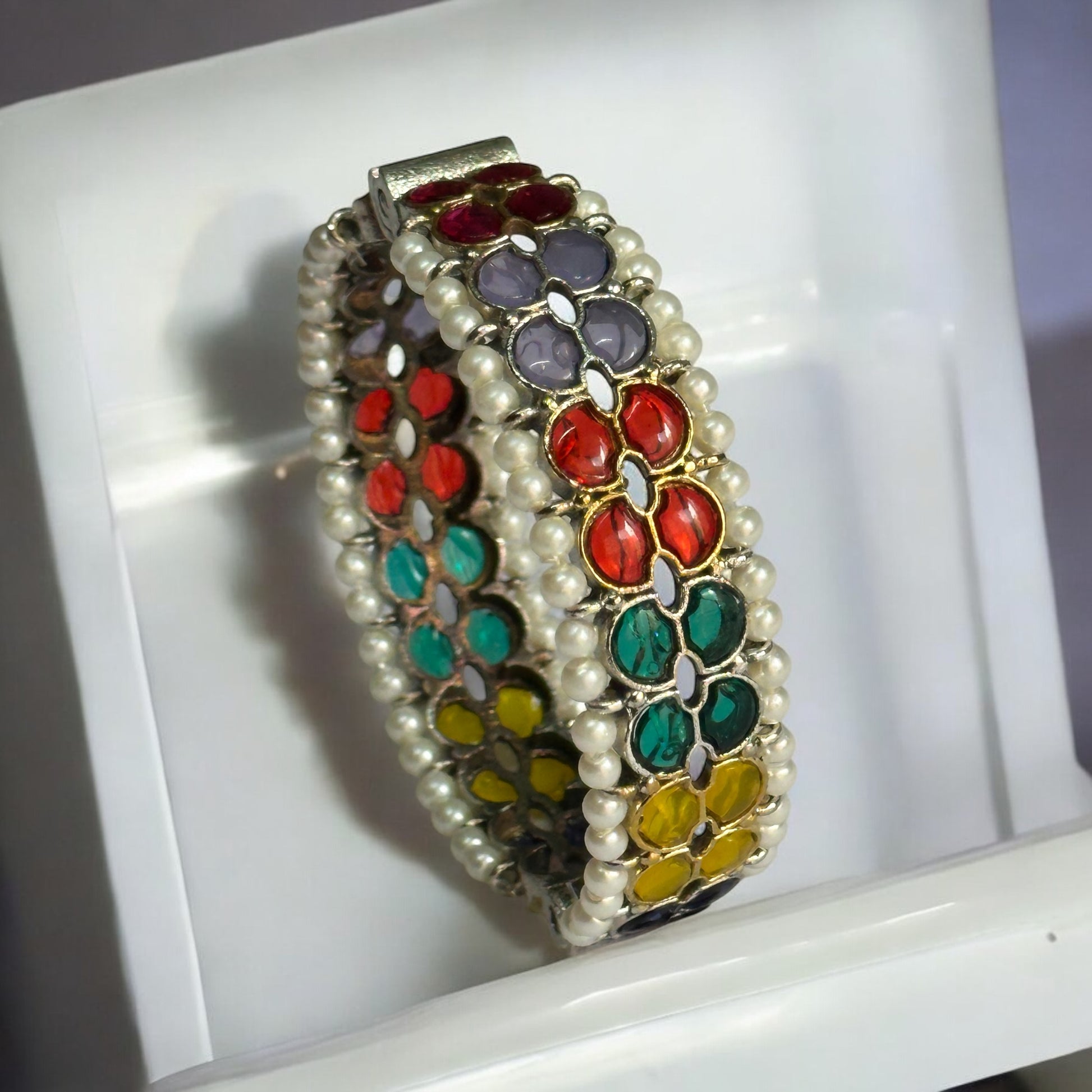 Silver replica bangle featuring vibrant multicolored enamel floral patterns and delicate pearl accents, displayed on a white background to highlight its intricate craftsmanship.