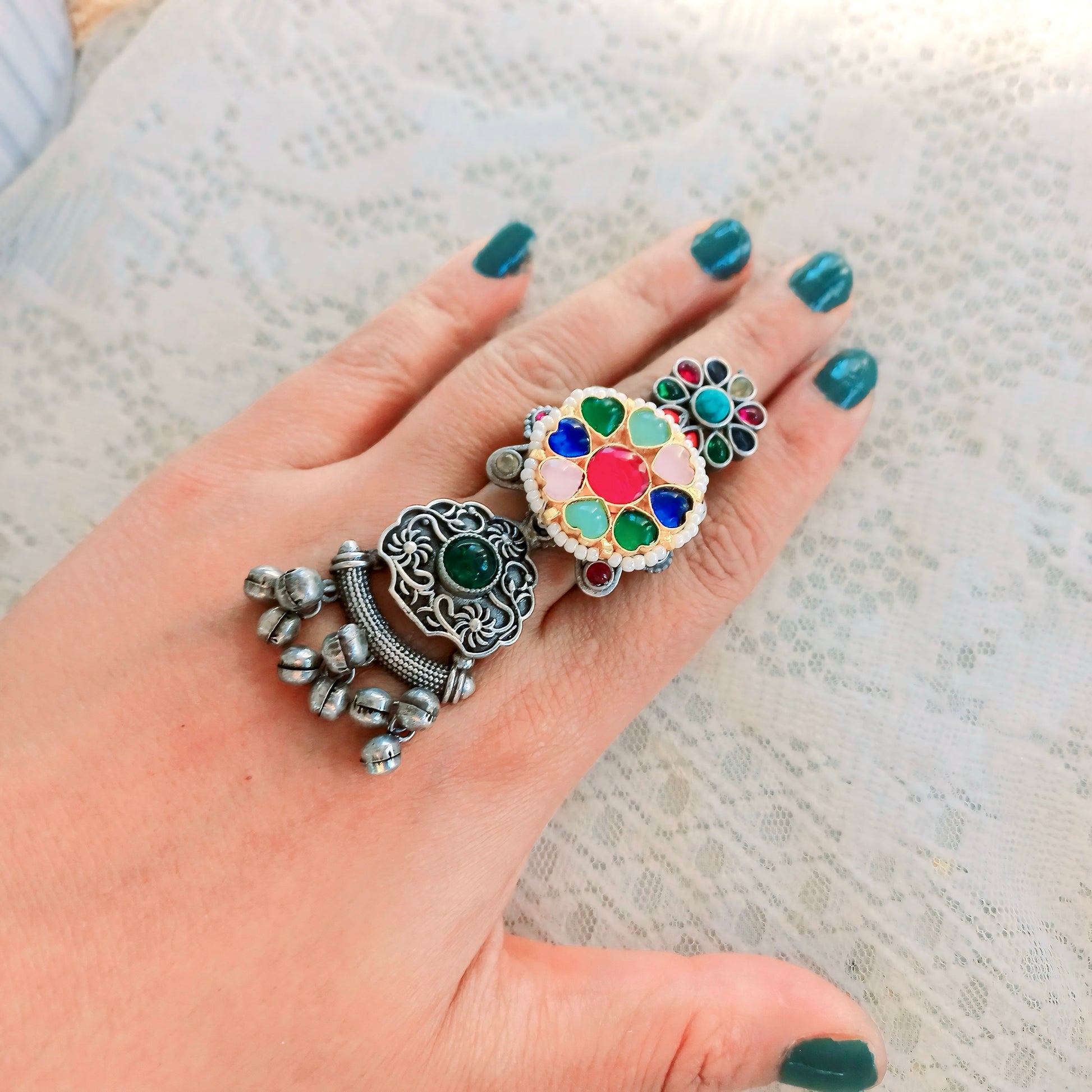 A woman's hand adorned with a Multicolor Fusion Ring, featuring an intricate long adjustable design with colorful gemstones, complementing an ethnic-inspired look.