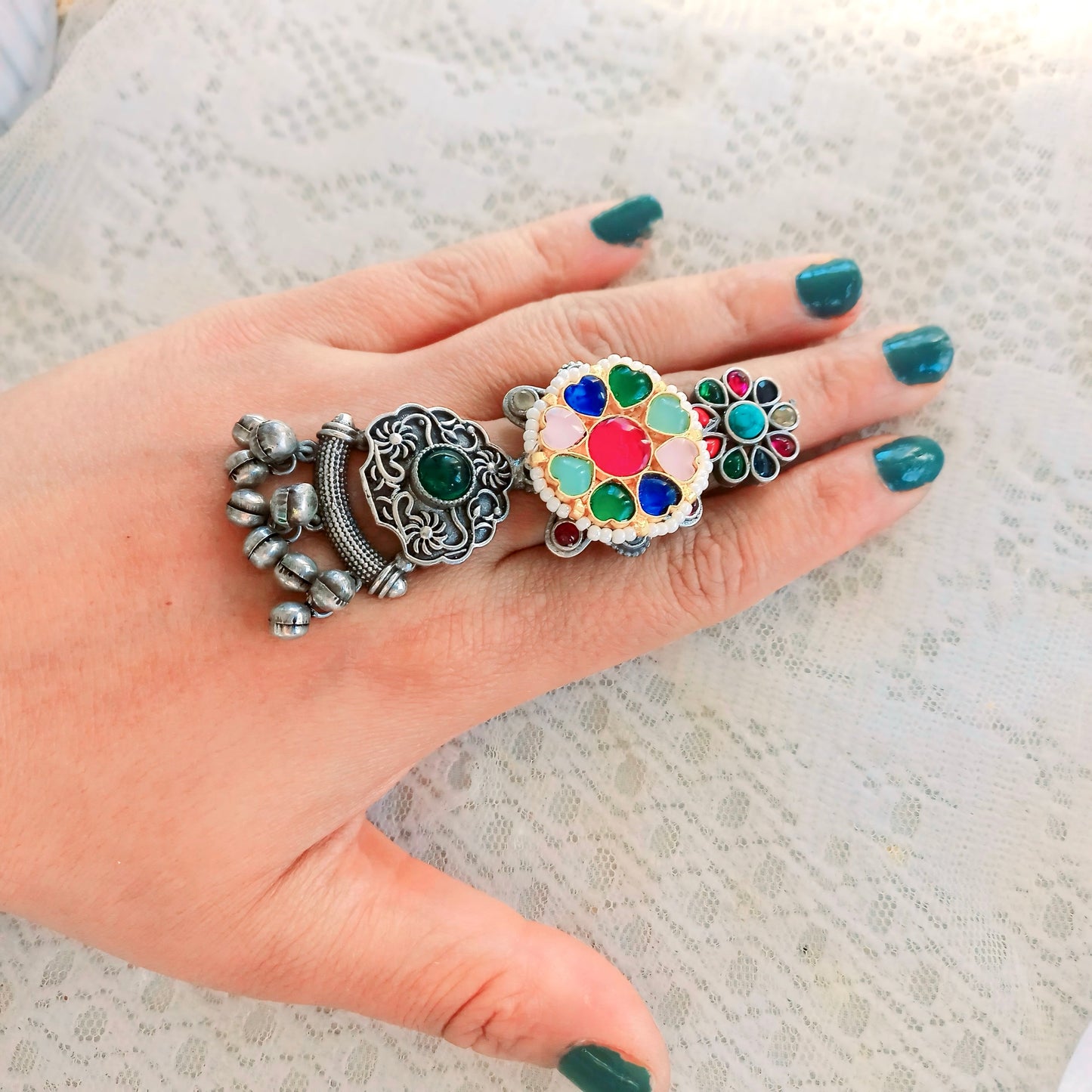 A woman's hand adorned with a Multicolor Fusion Ring, featuring an intricate long adjustable design with colorful gemstones, complementing an ethnic-inspired look.