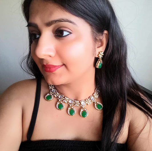 A model displaying Polki Kundan Premium Necklace with Matching Earrings – featuring floral motifs, green teardrop stones, and intricate polki and kundan detailing. Perfect for festive and cultural occasions.