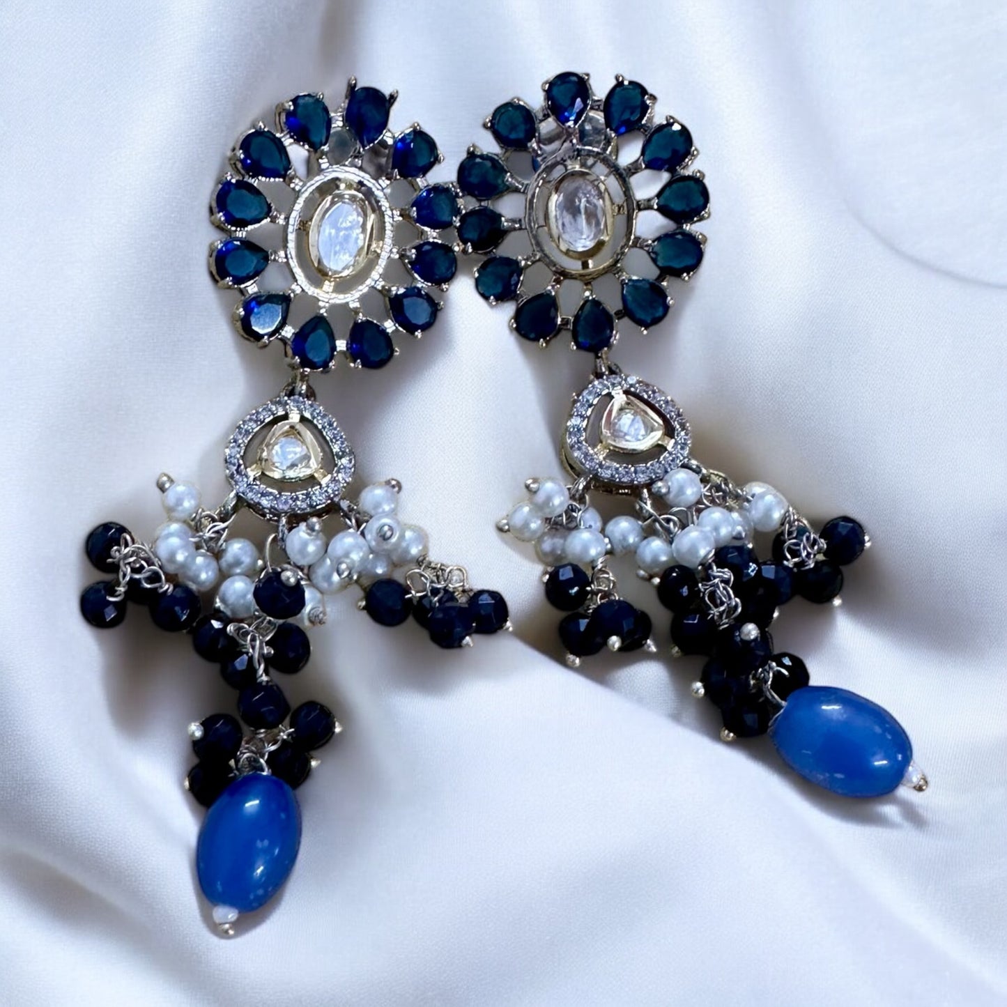 Polki Kundan with American Diamond Rani Har earrings lying on a white fabric background