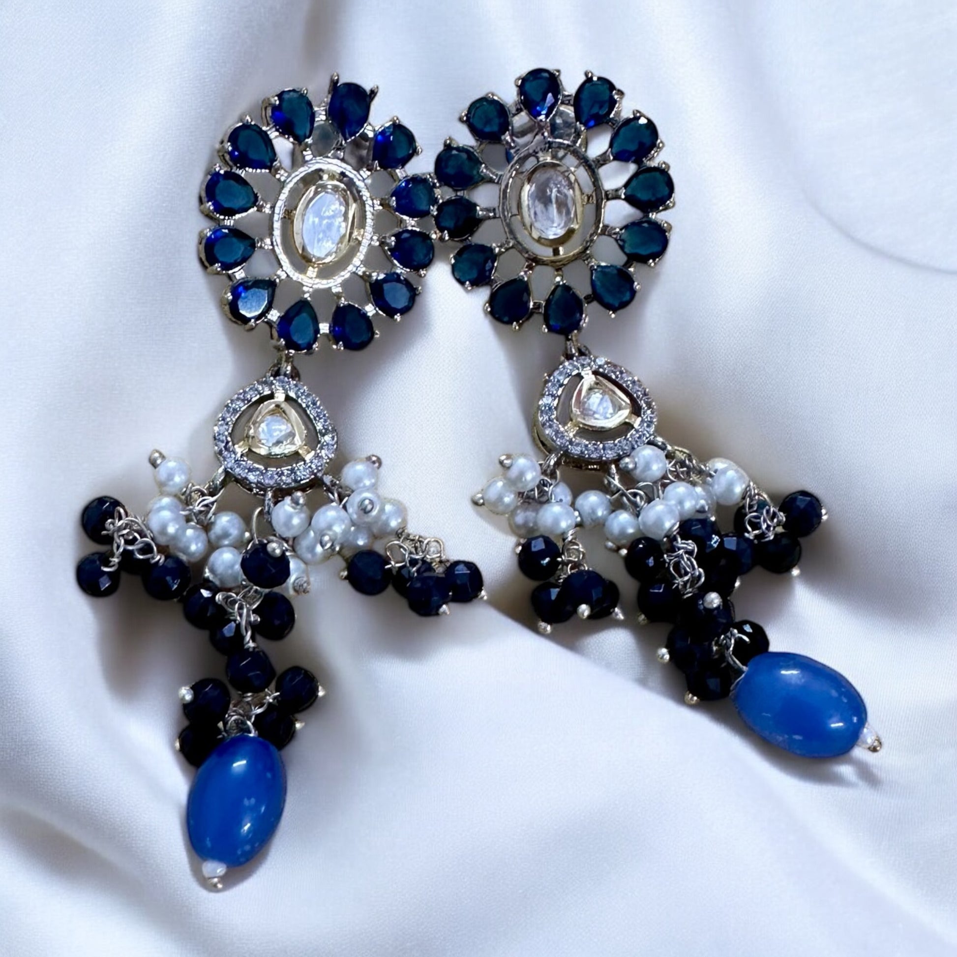 Polki Kundan with American Diamond Rani Har earrings lying on a white fabric background