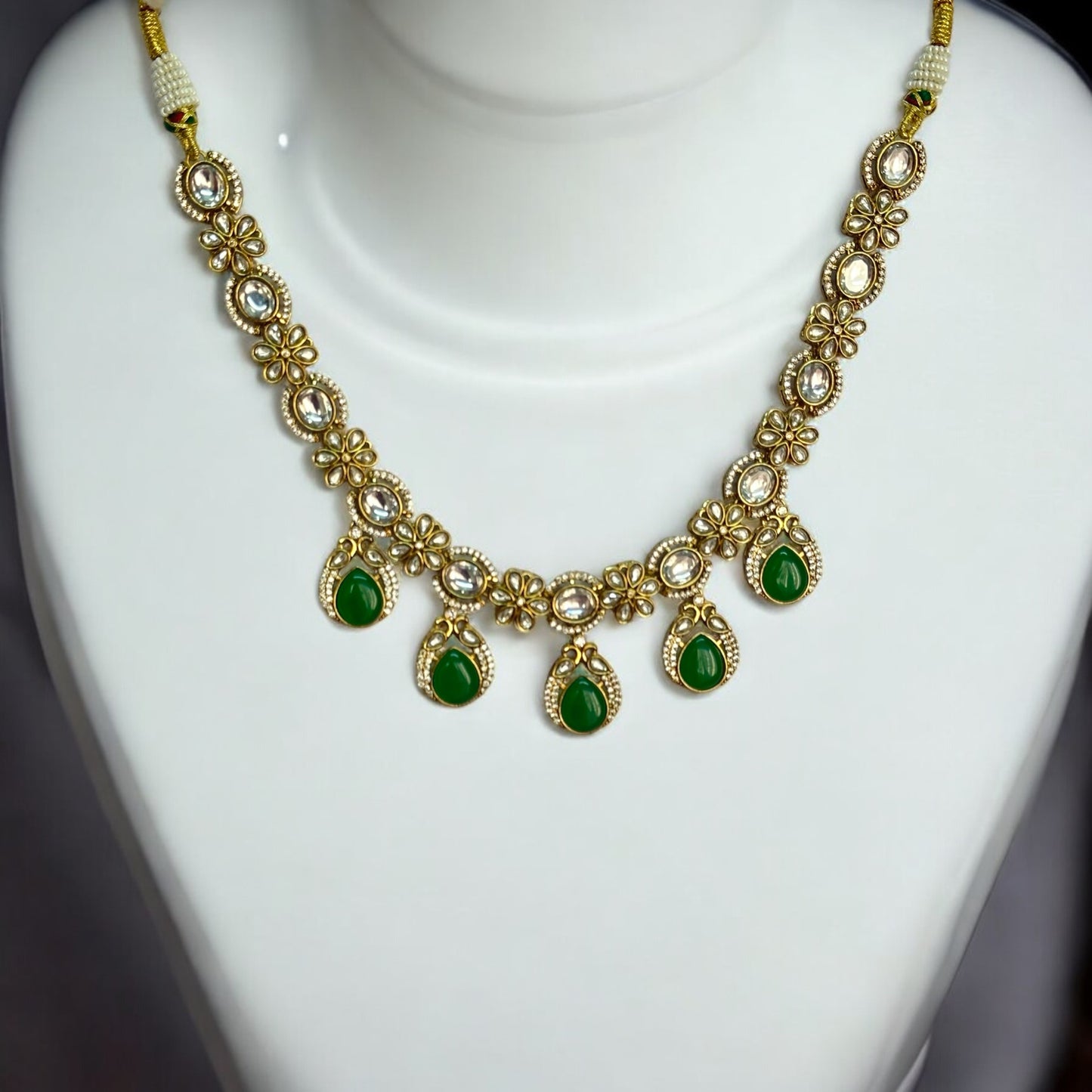 Polki Kundan Premium Necklace – featuring floral motifs, green teardrop stones, and intricate polki and kundan detailing. Perfect for festive and cultural occasions.