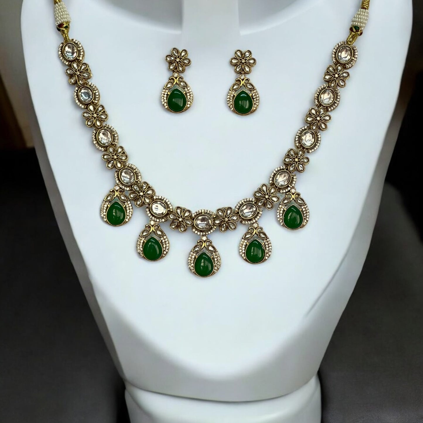 Polki Kundan Premium Necklace with Matching Earrings – featuring floral motifs, green teardrop stones, and intricate polki and kundan detailing. Perfect for festive and cultural occasions.