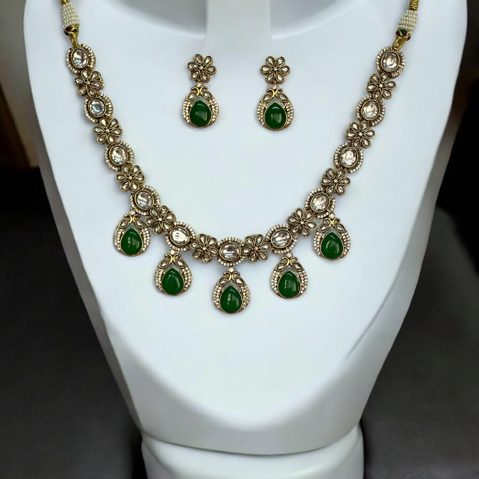 Polki Kundan Premium Necklace with Matching Earrings – featuring floral motifs, green teardrop stones, and intricate polki and kundan detailing. Perfect for festive and cultural occasions.