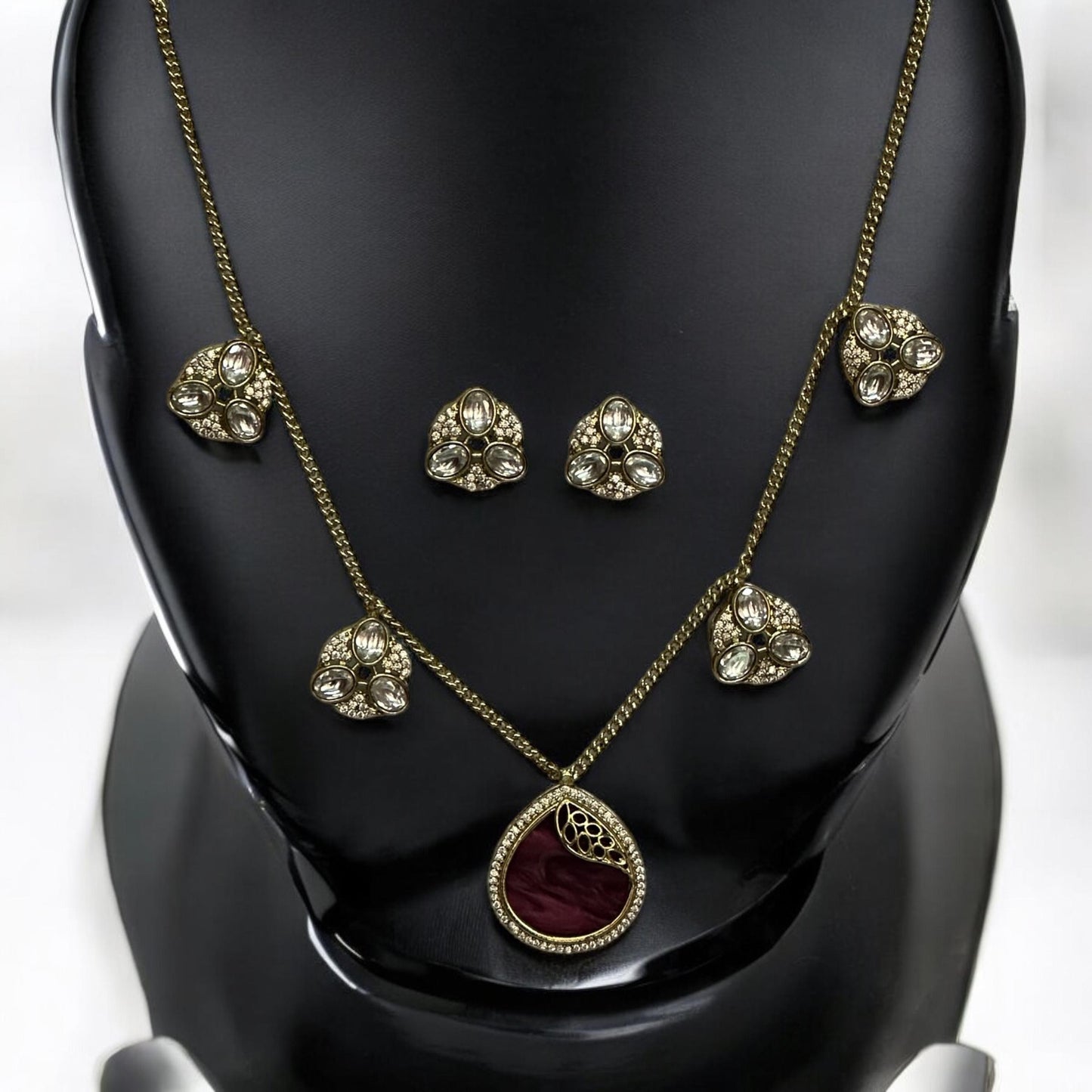 Premium moissanite pendant charms necklace set in royal purple with matching moissanite earrings, displayed on a black stand