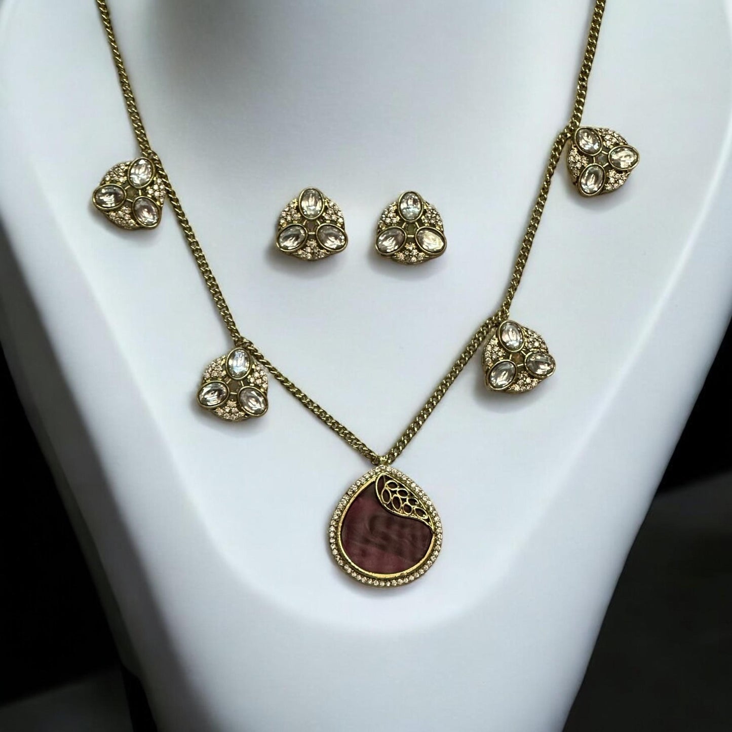 Premium moissanite pendant charms necklace set in royal purple with matching moissanite earrings, displayed on a white stand