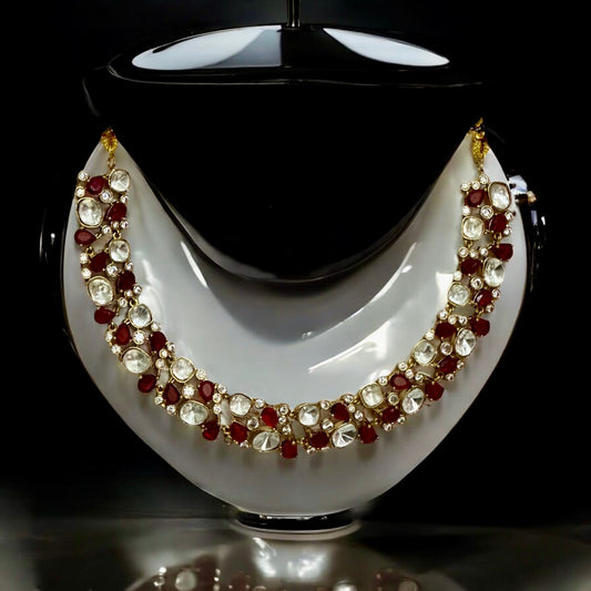 Premium Polki Kundan necklace with red diamond accents and matching earrings on white black jewellery display stand background – Bella & Diva