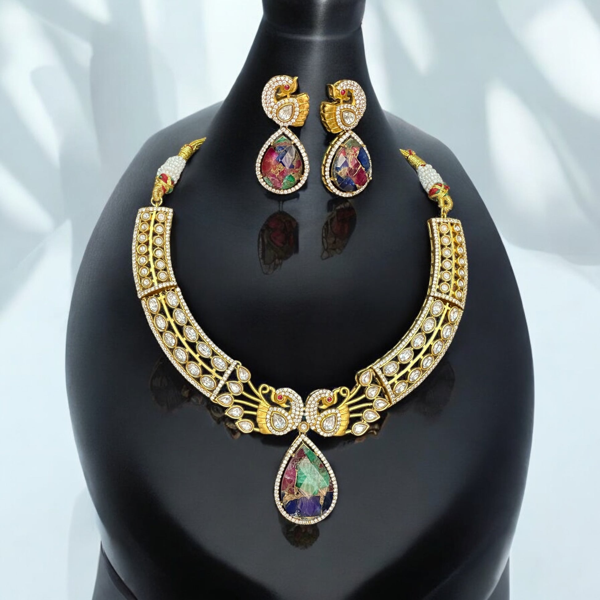 Premium doublet multicolor stone necklace featuring intricate moissanite kundan work in a peacock-inspired design, paired with matching earrings, displayed on a black bust against a soft background.