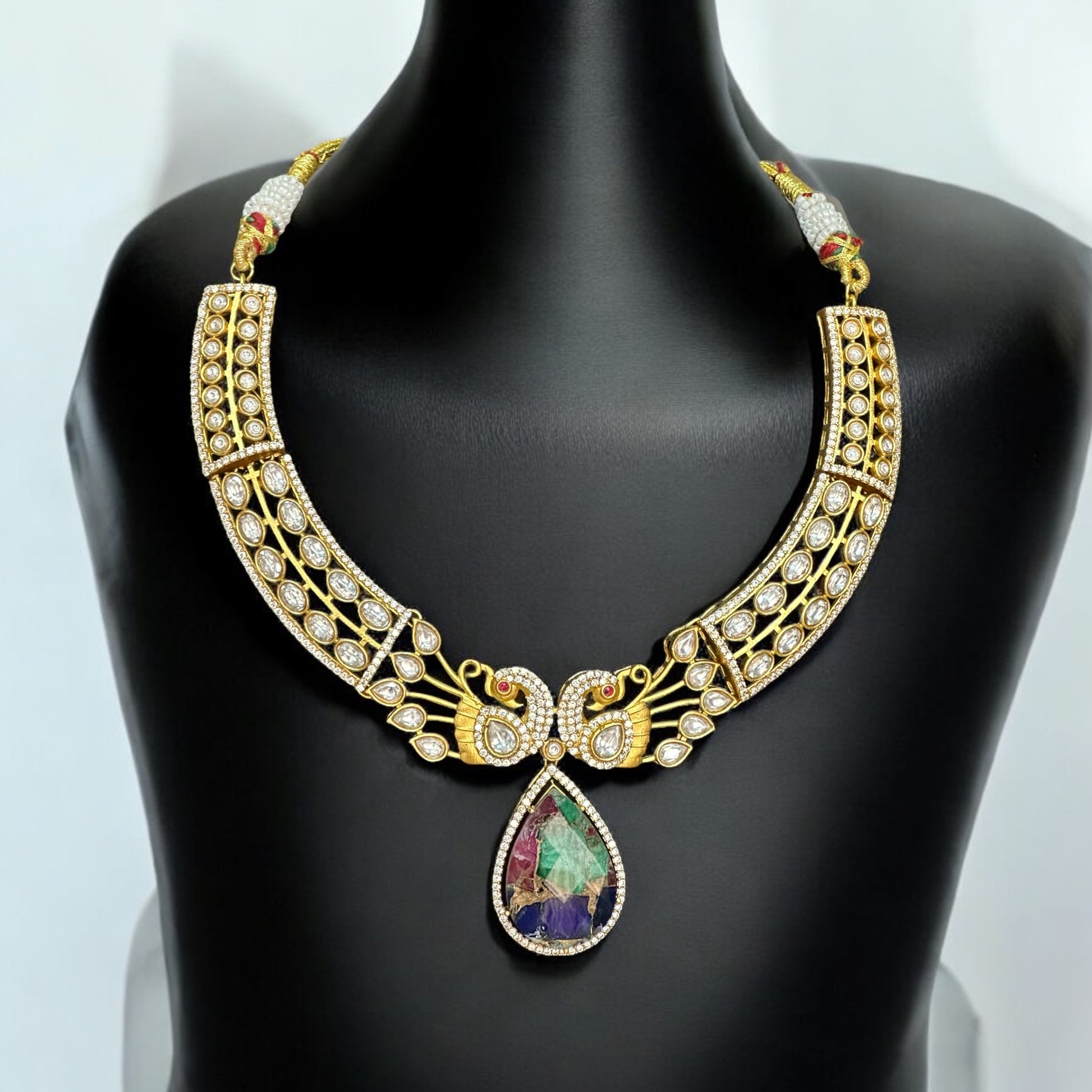 Premium doublet multicolor stone necklace featuring intricate moissanite kundan work in a peacock-inspired design, displayed on a black bust against a soft background.