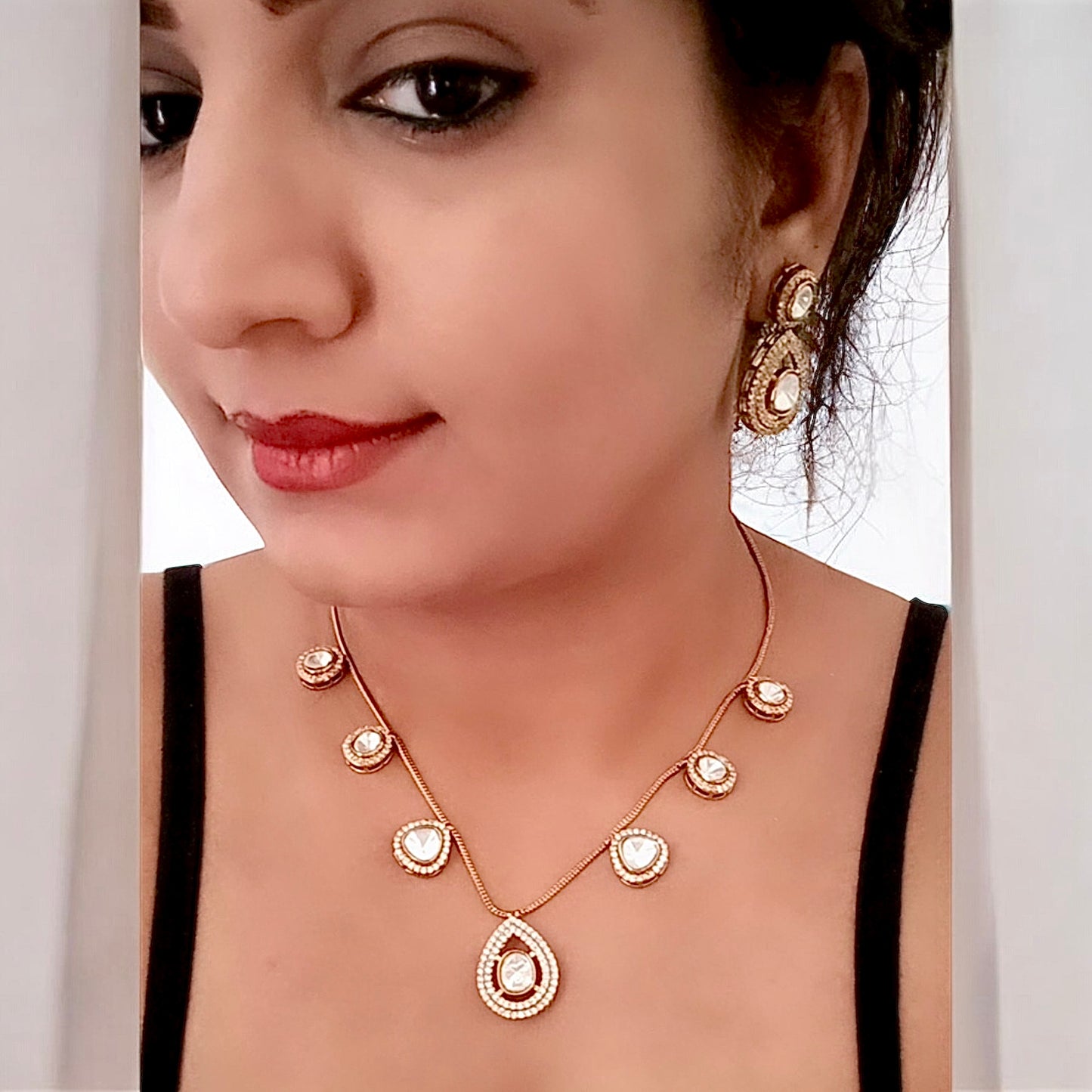 A model displaying aMoissanite chain design necklace set with earrings in golden colour.