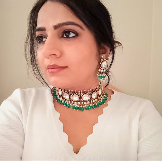 A model displaying bella & Diva's Premium Moissanite Polki Kundan Choker with Earrings in Green – luxurious choker featuring moissanite polki stones, kundan detailing, pearl accents, and green bead drops. Ideal for weddings and festive occasions. Buy it online in UK from Bella & Diva Ltd