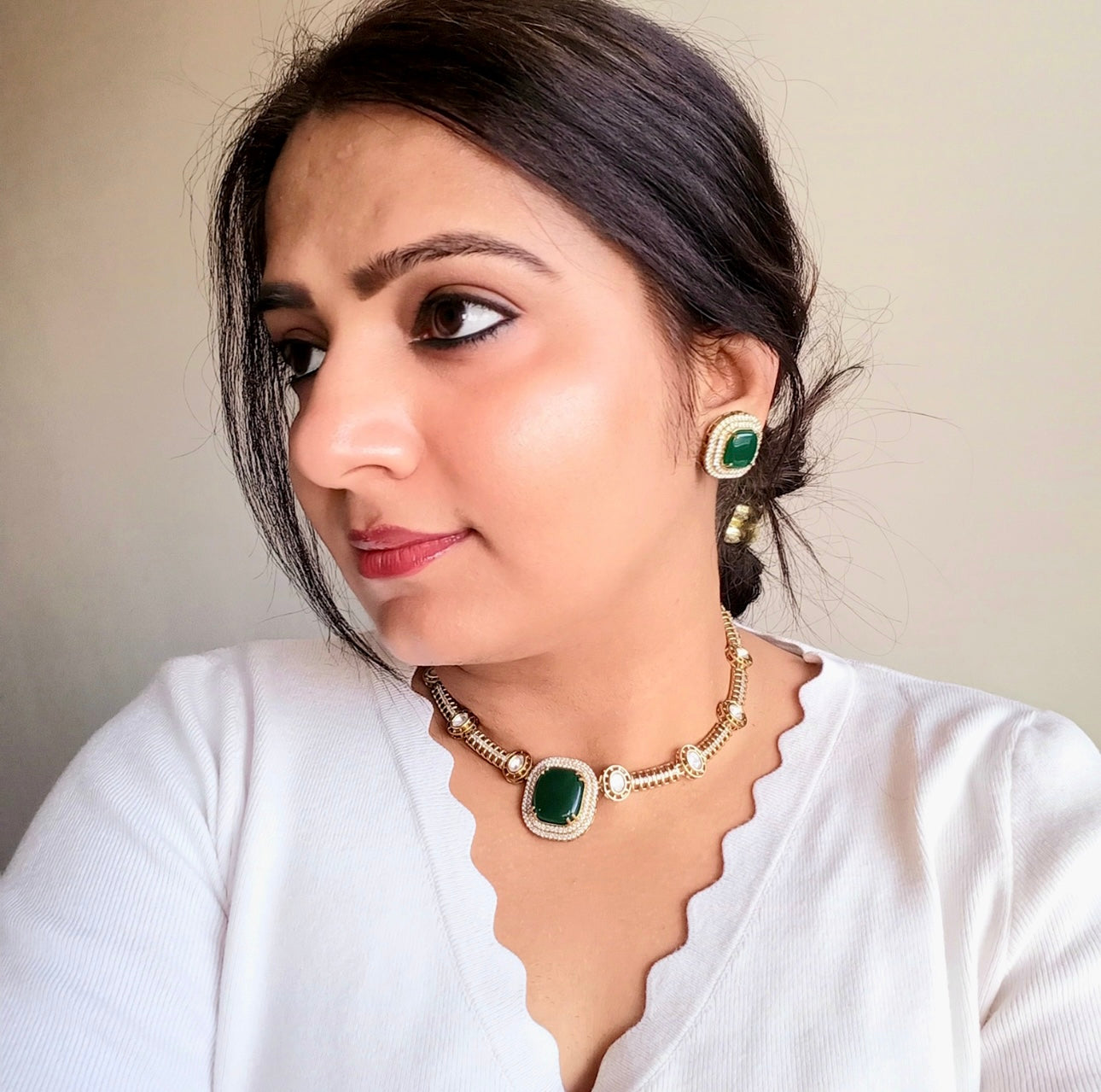 A model displaying a green coloured Premium Polki Kundan Necklace Set with Earrings in Green Color – elegant gold-tone necklace with vibrant green stones, polki kundan work, and matching stud earrings. Perfect for weddings and festive occasions.