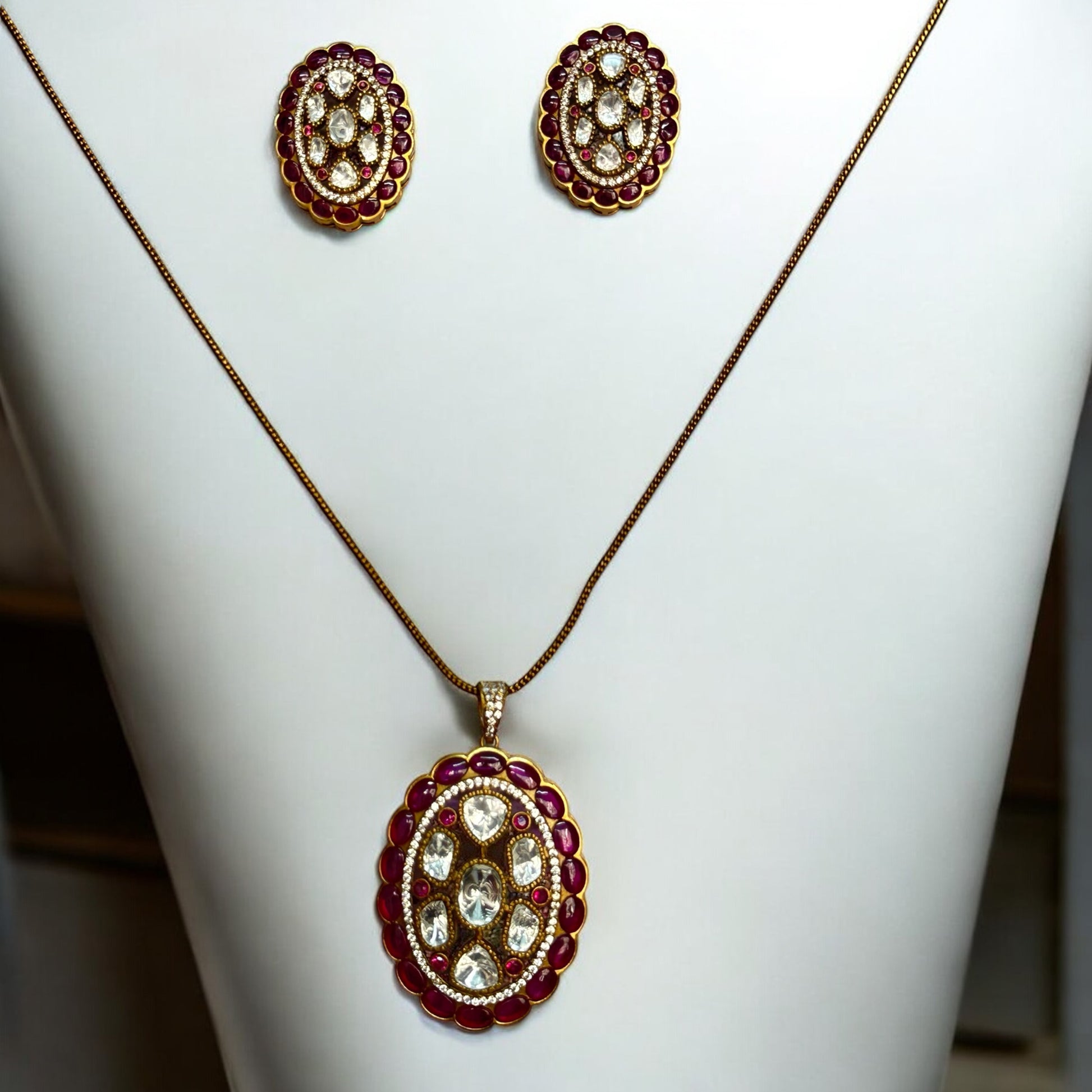 Real Moissanite Pendant Set with Big Ruby-Coloured Stud Earrings, featuring intricate oval-shaped designs and luxurious stone detailing.