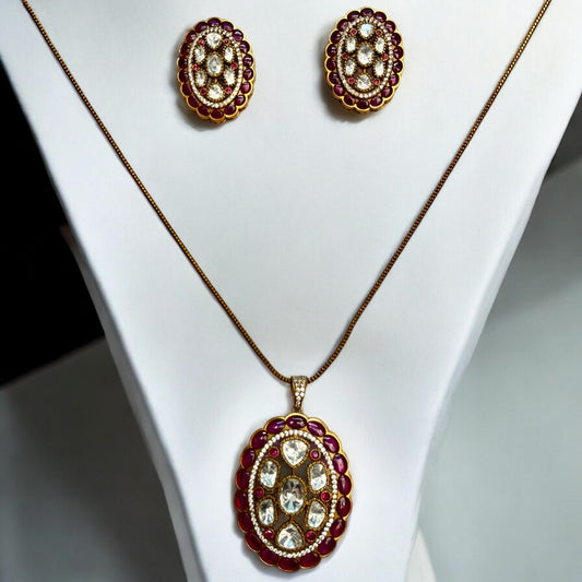 Real Moissanite Pendant Set with Big Ruby-Coloured Stud Earrings, featuring intricate oval-shaped designs and luxurious stone detailing  placed on a white jewellery display stand.